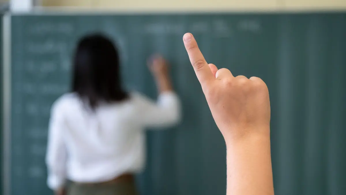 Ein Schüler meldet sich während einer Unterrichtsstunde im Friedrich-Schiller Gymnasiums, während die Lehrerin an die Tafel schreibt. Mit Spannung werden die Ergebnisse der neuen Pisa-Studie erwartet. Was in der Studie getestet wird und warum sie eine so große Rolle spielt. +++ dpa-Bildfunk +++