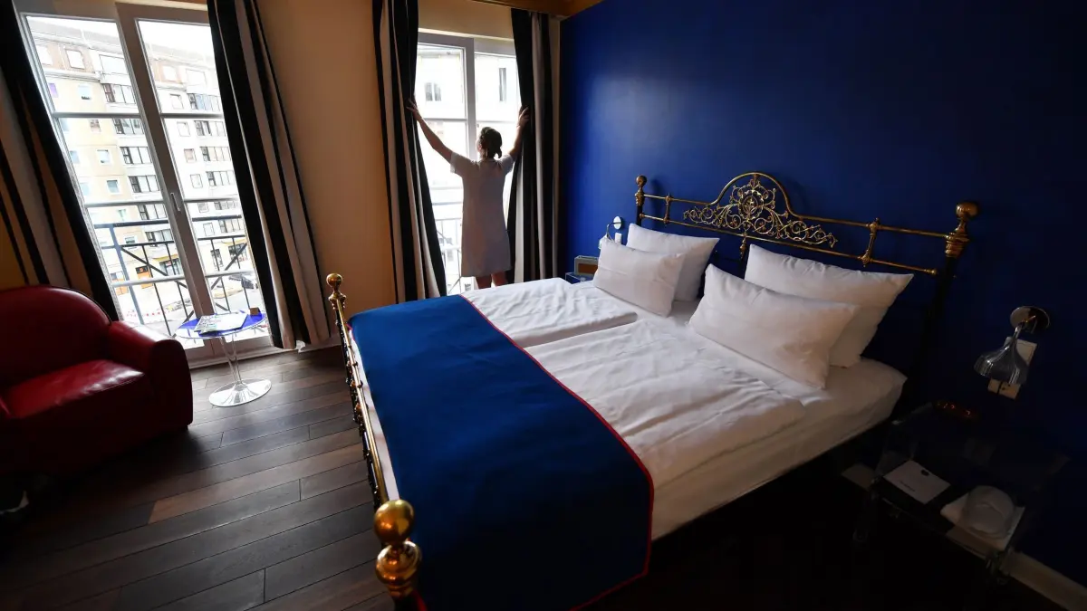 Eine Servicekraft öffnet in einem Hotelzimmer im privaten inhabergeführten Berliner Boutique– und Design–Hotel THE DUDE die Gardinen, fotografiert am 14.07.2016 in der Köpenicker Straße 92 in Berlin Mitte. (zu dpa: „Übernachtungssteuer künftig auch für Geschäftsreisende»)