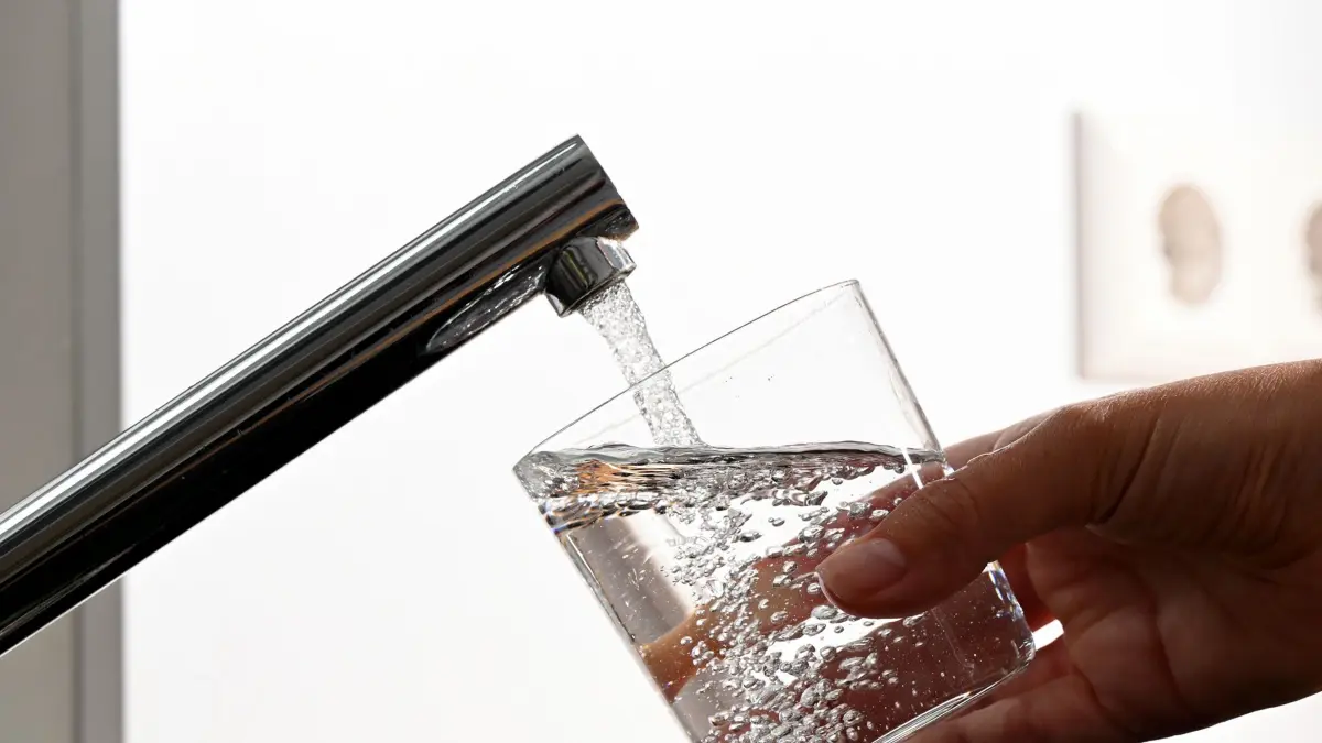 ILLUSTRATION - Eine Hand hält ein Wasserglas unter einen Wasserhahn. (zu dpa: "Keime in Bretzfelder Trinkwasser entdeckt - Abkochgebot") +++ dpa-Bildfunk +++