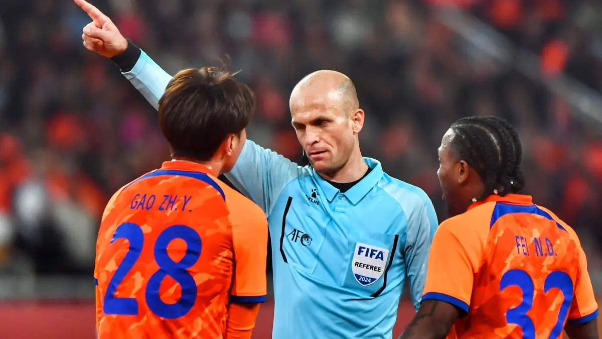Shandong Taishan’s Gao Zhunyi (L) receives a warning from referee Adham Mohammad Makhadmeh during the AFC Champions League quarterfinal match between Japan's Yokohama F Marinos and China's Shandong Taishan in Jinan, in China’s eastern Shandong province on March 6, 2024. (Photo by AFP) / China OUT