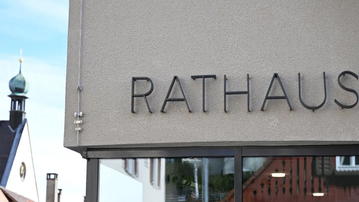 Ein Hinweisschild mit der Aufschrift Rathaus hängt vor einem Rathaus Gebäude in Rottenburg am Neckar.
