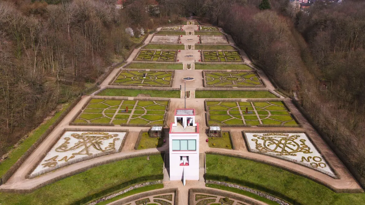 Globusschau von Ingo Günther in Schleswig: PRODUKTION - 28.03.2024, Schleswig-Holstein, Schleswig: Die Sonne scheint auf den Barockgarten und das Globushaus am Schloss Gottorf. Es ist Schauplatz für eine Ausstellung mit Globen des in New York lebenden deutschen Künstlers Ingo Günther. Günther hat seit 1988 auf mehr als 1000 Globen politische Konflikte, soziale Spannungen, ökologische und ökonomische Zusammenhänge mit grafischen Mitteln visualisiert. Die Schau im Globushaus ist zu sehen vom 29. März bis zum 27. Oktober 2024. (Luftaufnahme mit Drohne) Foto: Frank Molter/dpa +++ dpa-Bildfunk +++