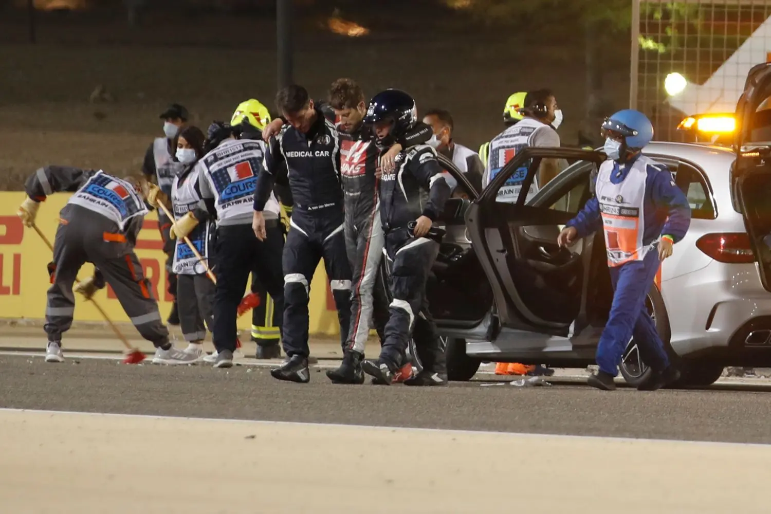 Romain Grosjean (Mitte) wird nach einem Unfall von medizinischen Personal von der Rennstrecke begleitet.
