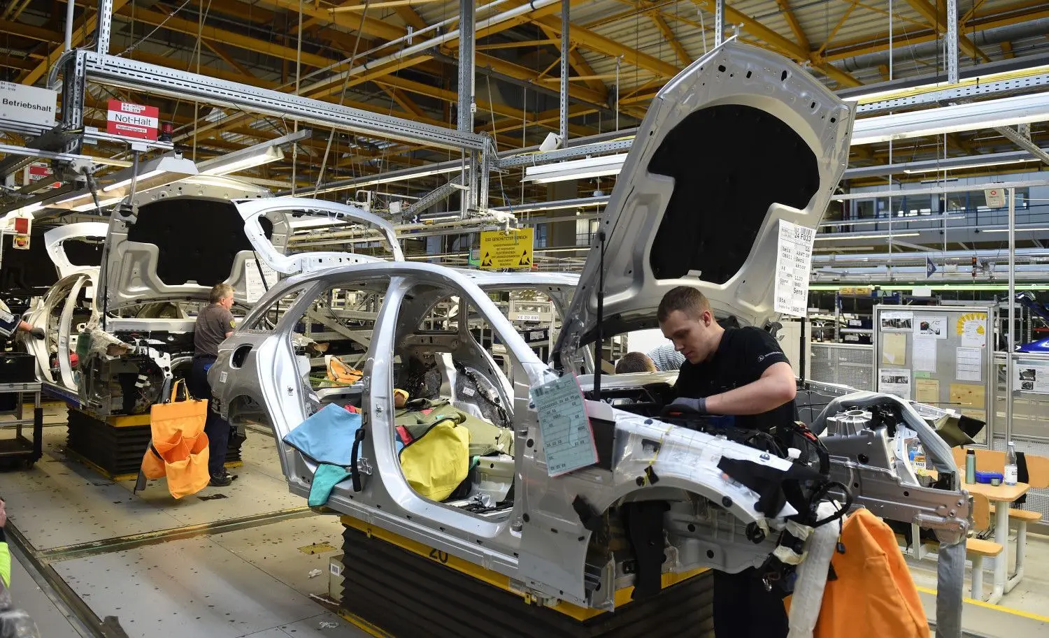 Mitarbeiter von Mercedes-Benz arbeiten im Werk in Bremen an einer C-Klasse. Künftig werden weniger Autos in dem Unternehmen mit Verbrennermotoren produziert. ⇥