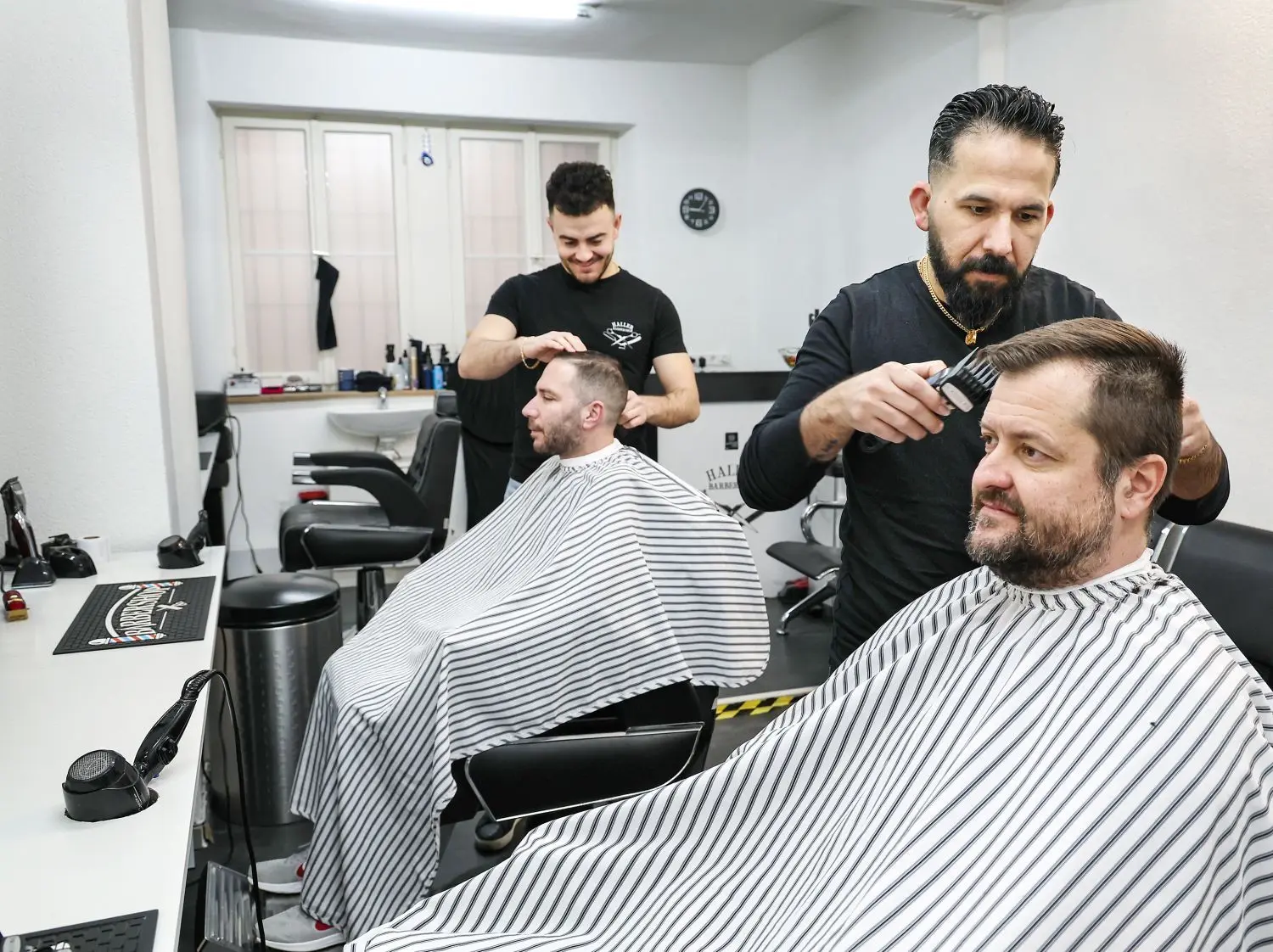 Im Haller-Barbershop in der Schwatzbühlgasse lassen sich Männer Haare und den Bart schneiden, wie Damir Marsicek (50), rechts im Bild, von Barbier Shaaban Qara Hassan. Einfach hingehen, das ist praktisch. Kunden warten bis zu einer Stunde. ⇥