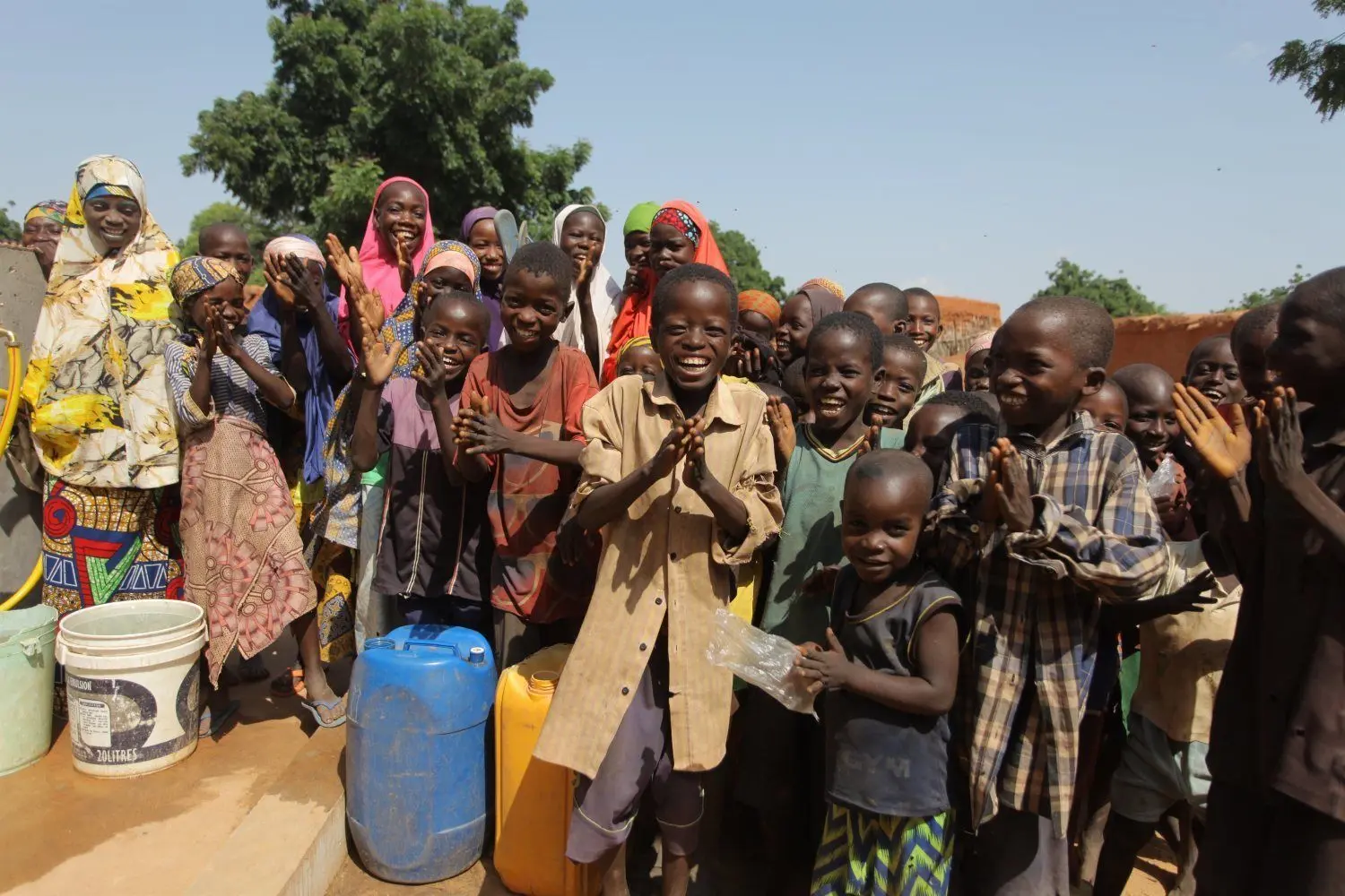 Große Freude bei den Kindern in Gomozo im Niger. Seitdem ihr Dorf an eine Wasserversorgung angeschlossen ist, müssen sie ihre Wasserkanister nicht mehr kilometerweit schleppen.⇥