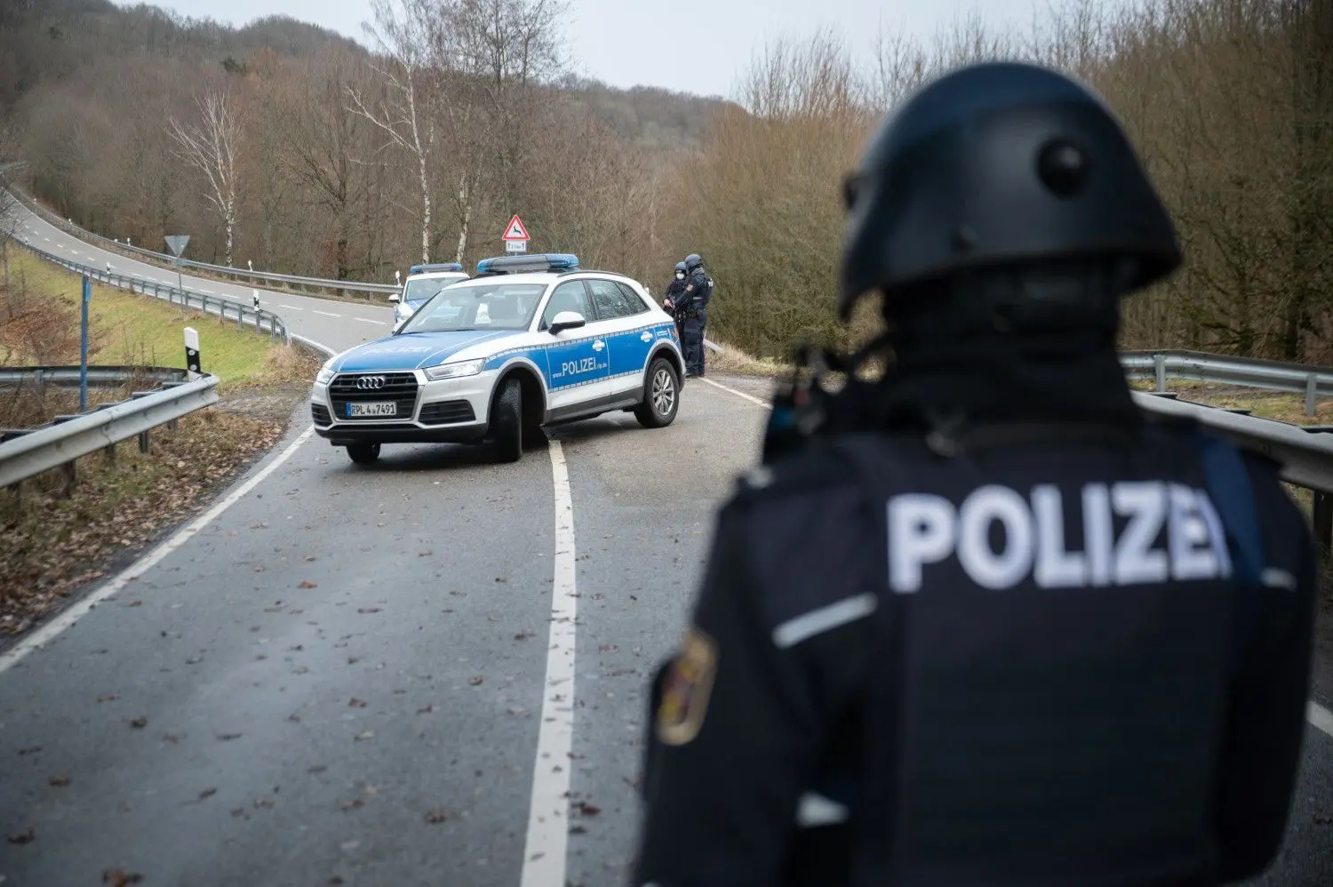 Polizeibeamte an einer Absperrung an der Kreisstraße 22 rund einen Kilometer von dem Tatort, an dem zwei Polizeibeamte durch Schüsse getötet wurden.