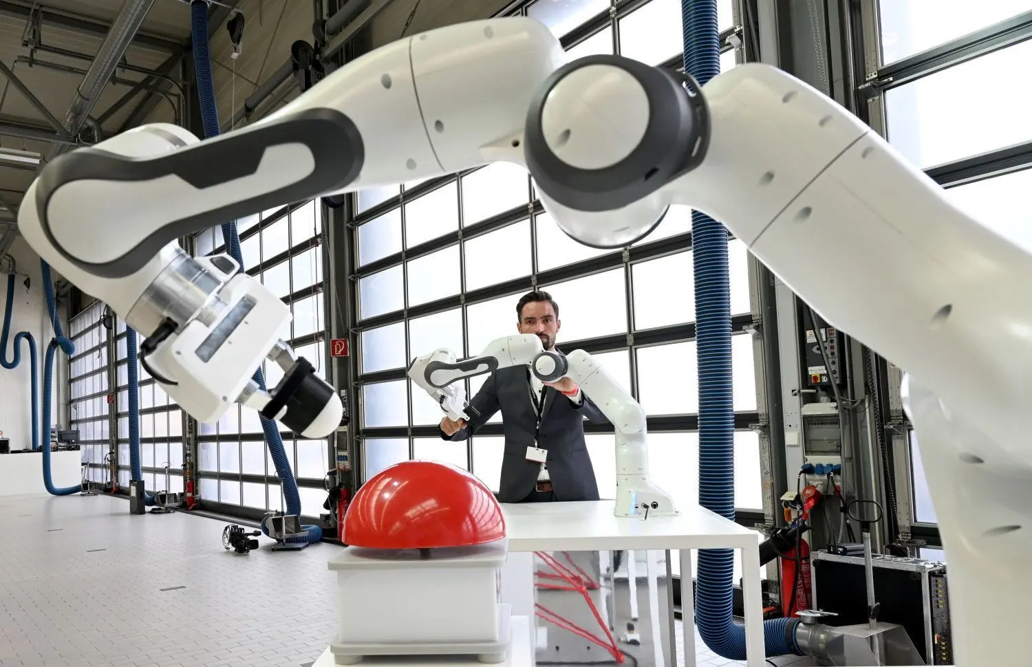 Ein Mitarbeiter demonstriert in Weissach die Fernsteuerung eines Roboterarms.⇥