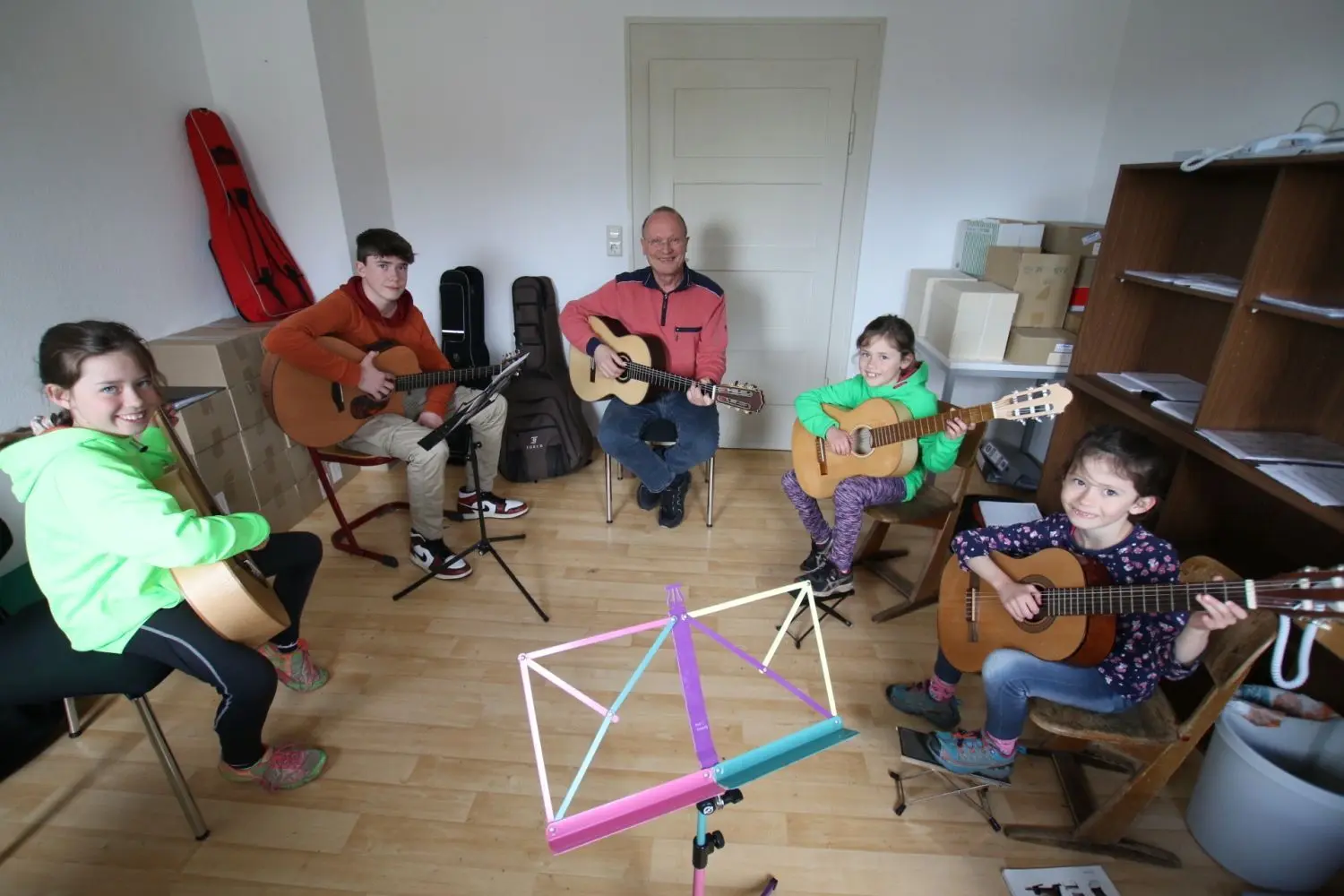 Musiklehrer Torsten Ebe (Mitte) bringt den Kindern der Familie Müller das Gitarre-Spielen bei: (von links) Emilia, Valentin, Elisa und Magda. Es fehlt: Annalena.⇥