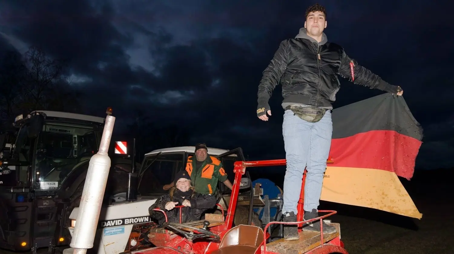 Sie wollen sich, ihre Arbeit und genauso das ganze Land bewahren: Ein junger Landwirt mit der deutschen Flagge.