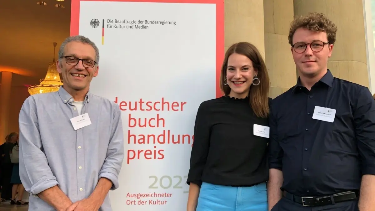 Ausgezeichnet für ihre Kulturarbeit: Samy Wiltschek (links) von der Bücherstube Jastram sowie Rasmus Schöll und Franziska Pentz von der Aegis Literatur-Buchhandlung vor dem Neuen Schloss in Stuttgart.