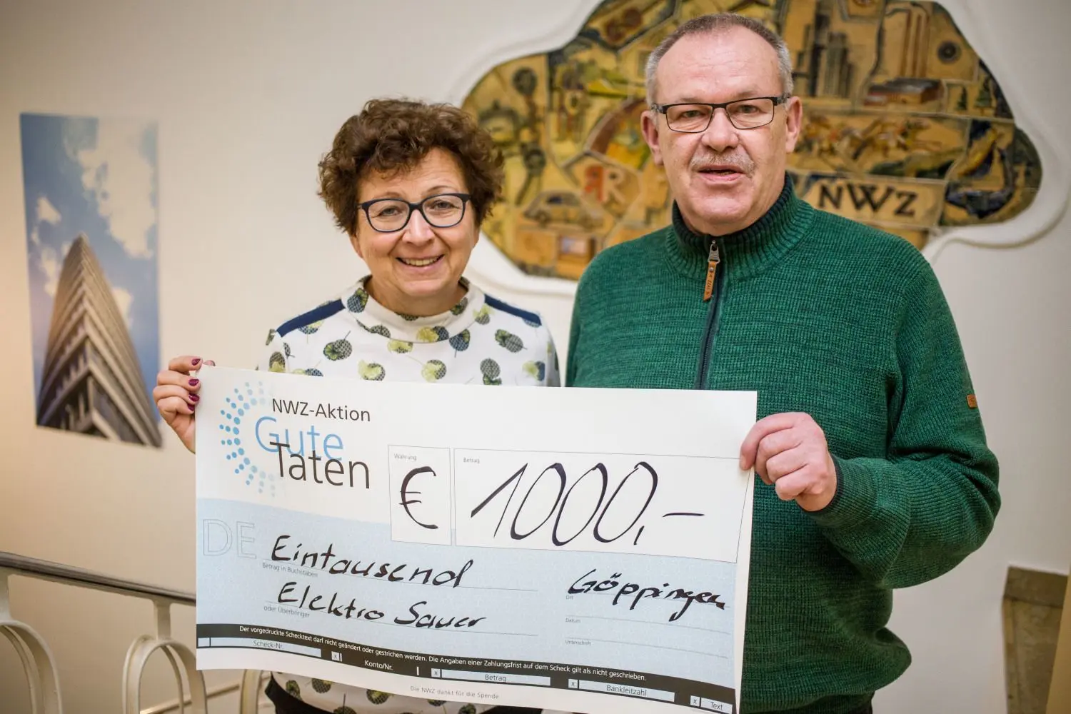 Wolfgang Blessing von Elektro Sauer übergibt Karin Tutas 1000 Euro für die NWZ-Aktion.