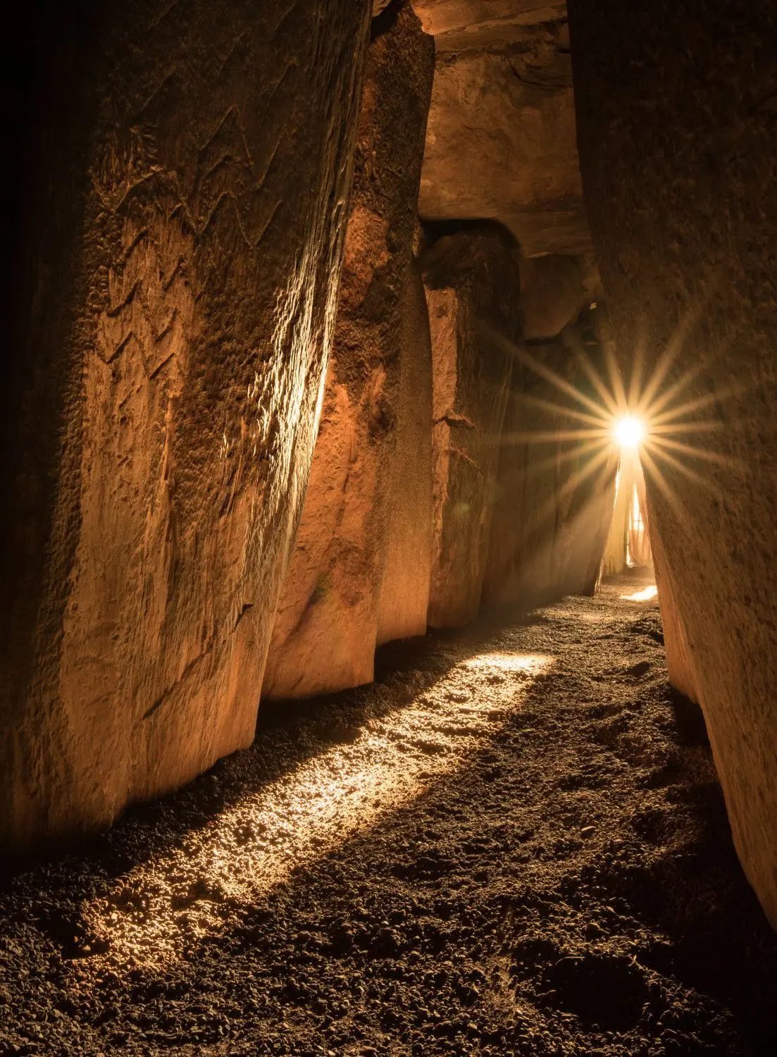 Sonne scheint in einen Gang in Newgrange.⇥