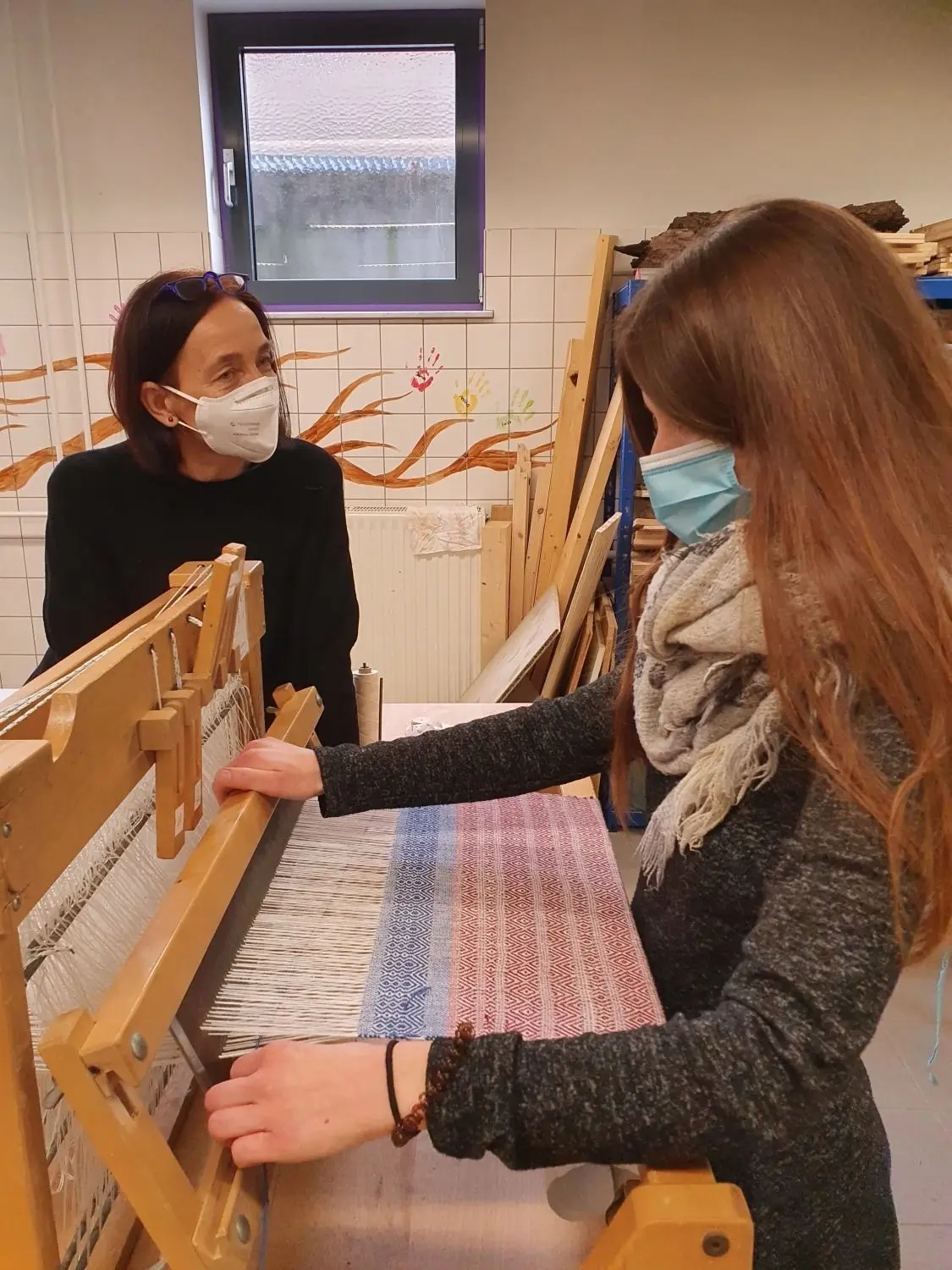 In kleinen Gruppen, mit Abstand und Maske: Die Haigerlocher Weberin Sibylle Weber (links) führte Schülerinnen und Schüler der Medischulen Balingen in die Kunst des Webens ein. Dabei entstanden interessante Gespräche ebenso wie schöne Dinge.