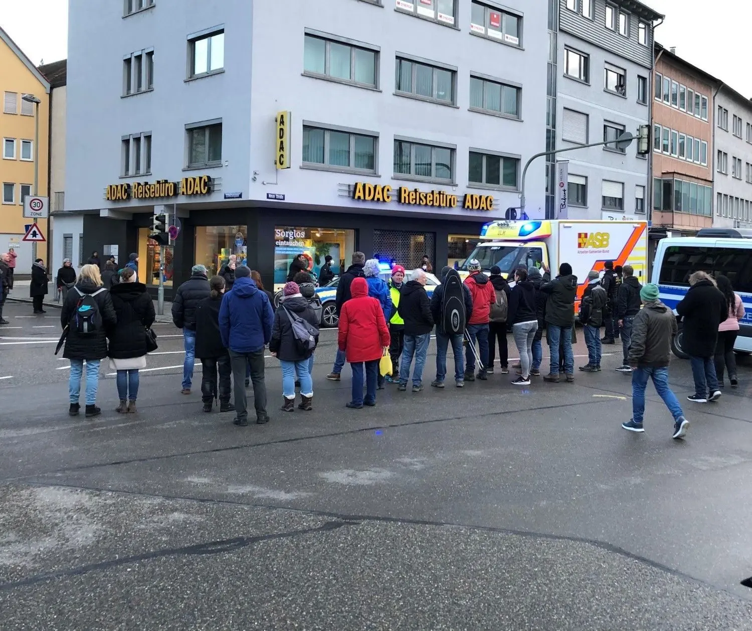 Ein Krankenwagen kommt nicht durch, weil die Polizei für die „Spaziergänger“ den Verkehr gestoppt hat. Eilends müssen die Beamten ihre Fahrzeuge zur Seite rangieren.