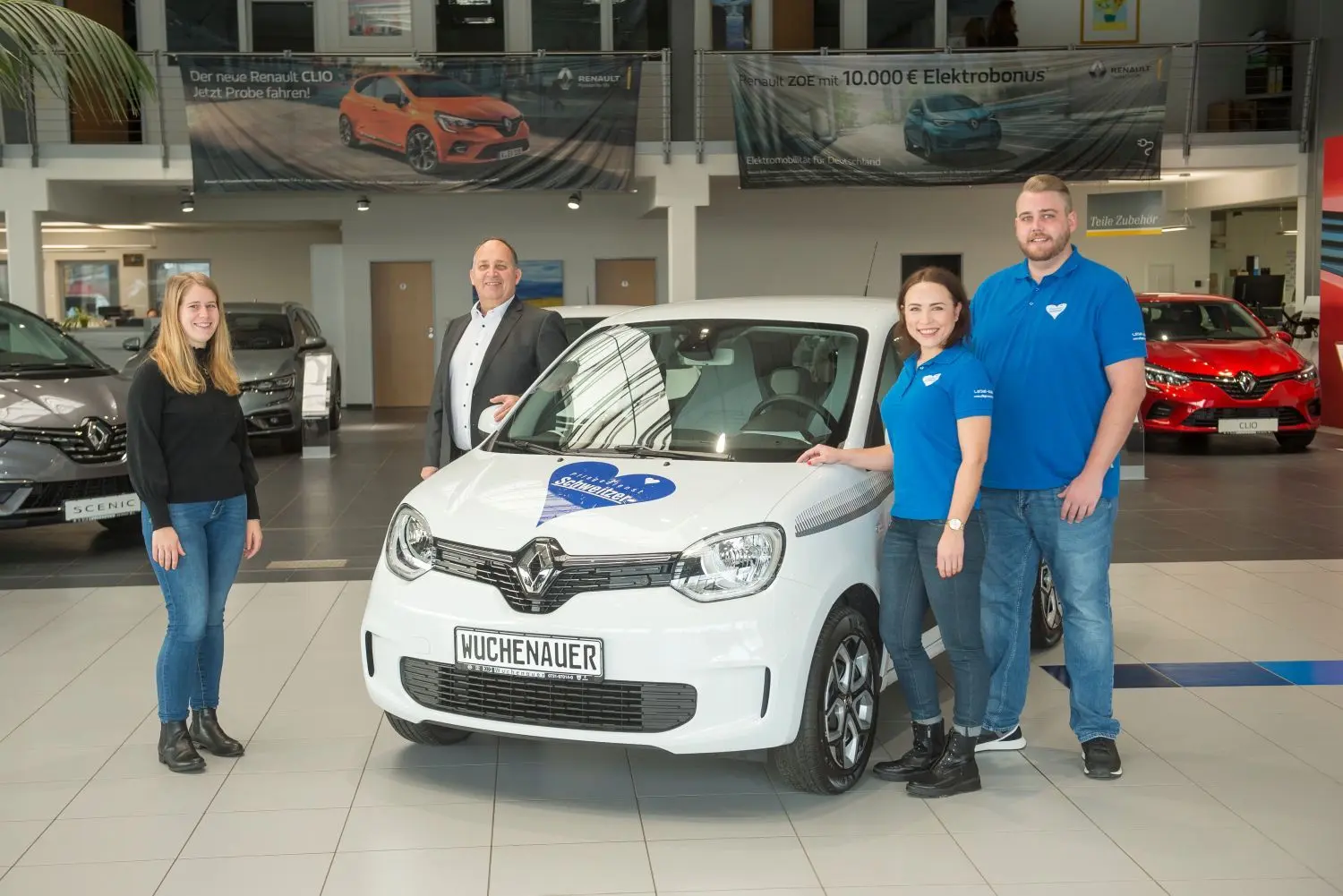 Ihr Logo prangt schon auf dem Kühler: Matthias Schweitzer (r.) und Anna Kirjuhin bei der Autoübergabe mit Lisa und Klaus Wuchenauer.