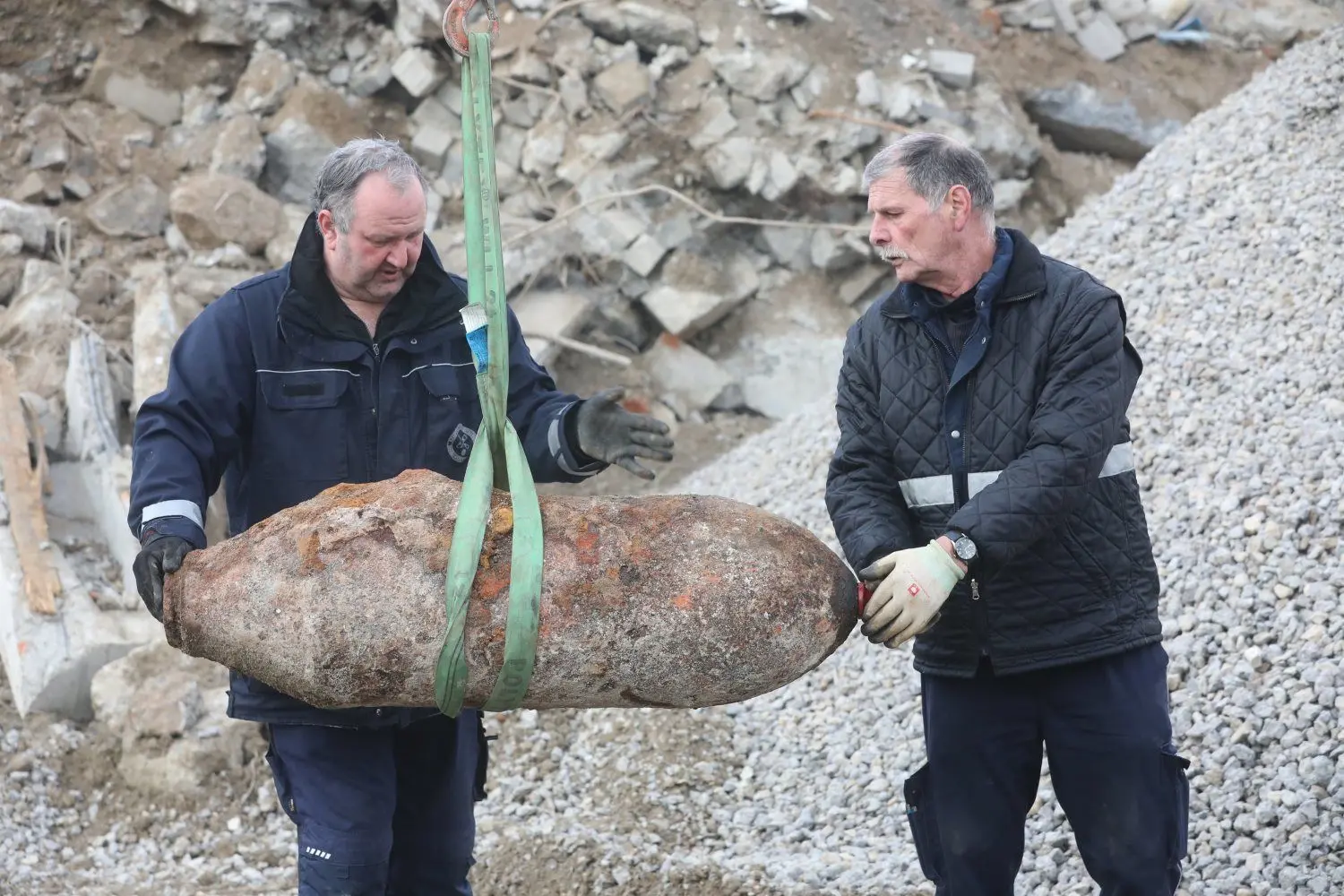 Mit Hilfe eines Baggers laden die Entschärfer Robert Mess (l.) und Joachim Leippert die Bombe in ihr Spezialfahrzeug.
