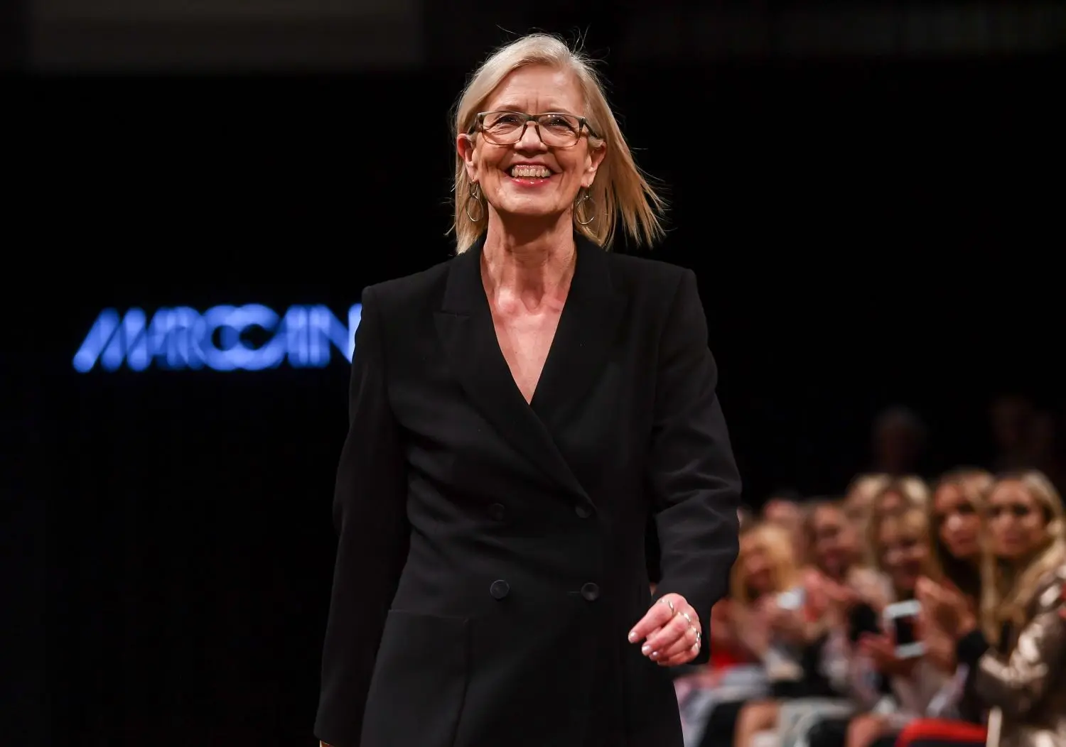 Chefdesignerin Karin Veit läuft nach der Show strahlend  über den Laufsteg.