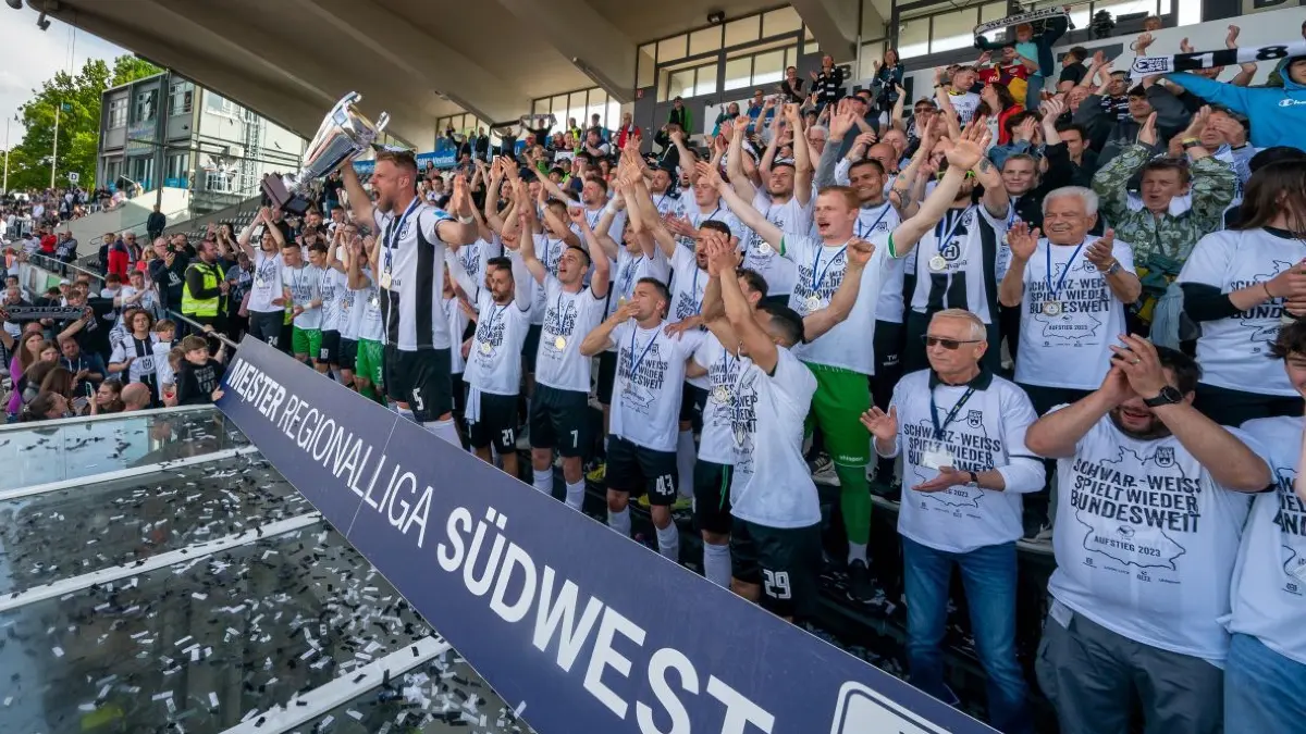 Da sind sie: Der Meisterpokal, die Mannschaft und die Fans. Der SSV Ulm 1846 Fußball ist aufgestiegen. Ausgerechnet an einem 20. Mai, der in der Vereinsgeschichte schon besonders ist.
SSV Ulnm Aufstieg Mannschaft feiert mit Pokal Online