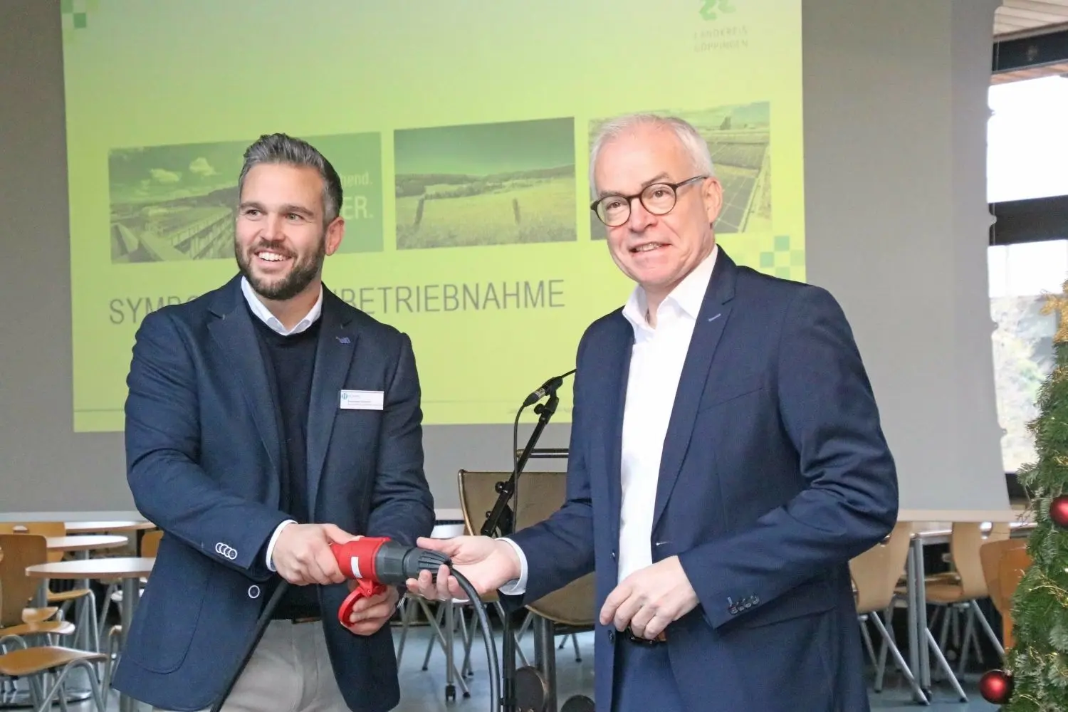 Alexander Hummel von der ausführenden Firma Hummel Systemhaus und Landrat Edgar Wolff beim symbolischen Einstecken der neuen PV-Anlage.