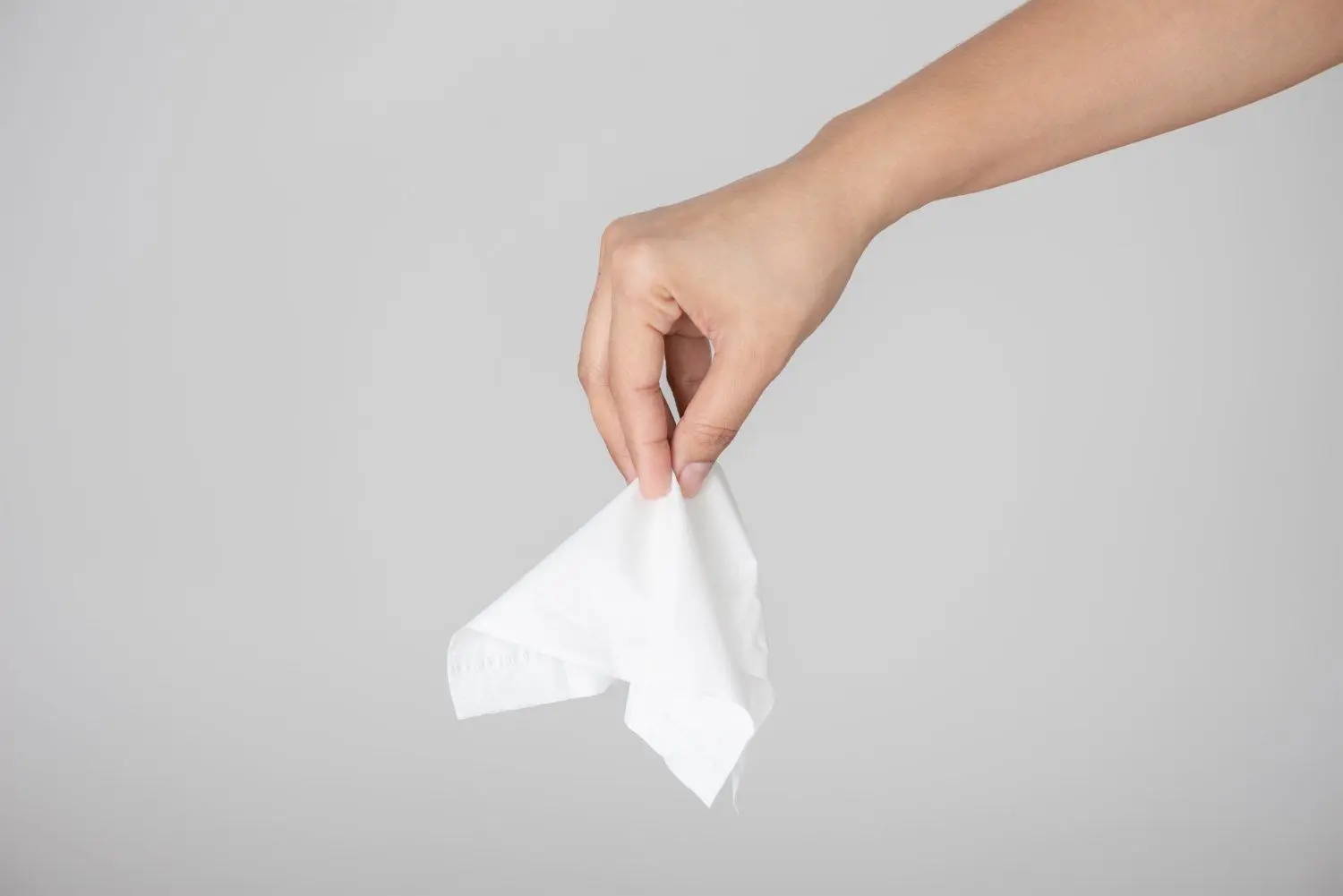 BEACHTEN: NPG-LIZENZ Download am 04.05.2020 für POLI Foto: ©De Monstera Studio/shutterstock.com, Lizenzfreie Stockfoto-Nummer: 1493112584 Woman hand picking white tissue paper from tissue box on gray background. Healthcare and hygiene concept. D Von De Monstera Studio⇥