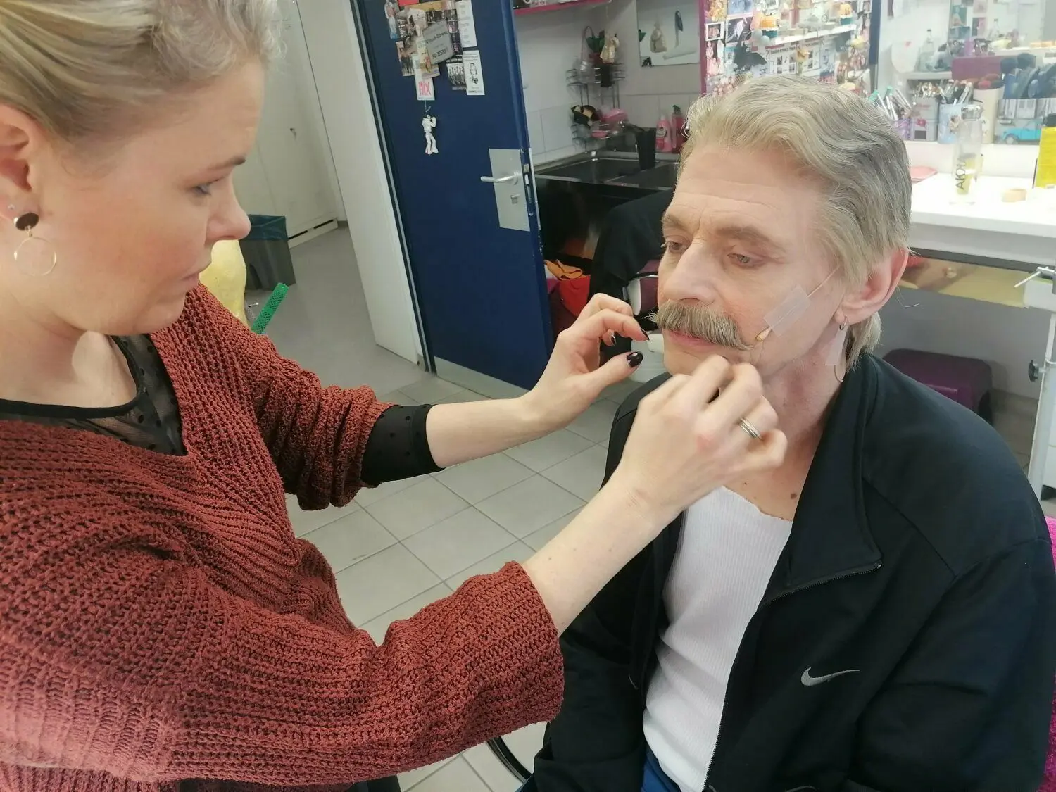 Nur nicht verrutschen: Maskenbildnerin Christiane Zwiebel klebt Schauspieler Nils Willers einen Schnurrbart an. Insgesamt viermal wird er beim Weihnachtsmärchen einen aufgeklebt und abgezogen bekommen. ⇥