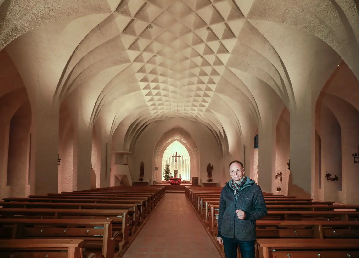 Wolfgang Heisler in der sanierten Kirche, in der das neue Lichtkonzept jetzt das Deckengewölbe zur Geltung bringt.⇥
