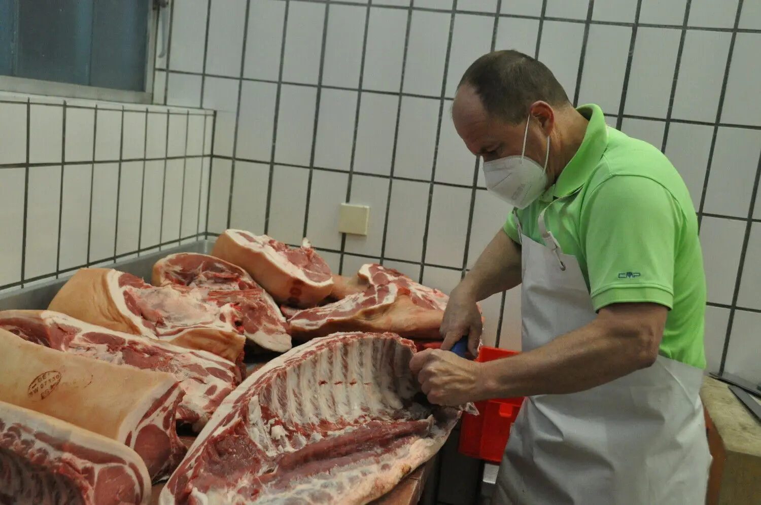 Der Emerkinger Metzger Alexander Scheible zerlegt ein Schwein und trennt die Teile für die Metzelsuppe ab. ⇥