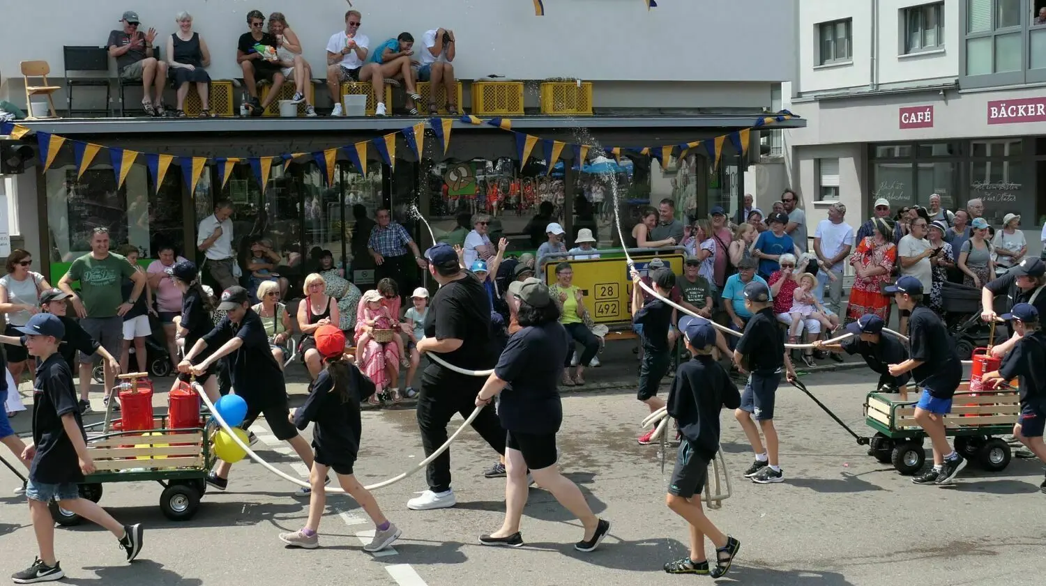 Wasserschlacht zwischen der Jugend-Feuerwehr und Zuschauern beim Festumzug.