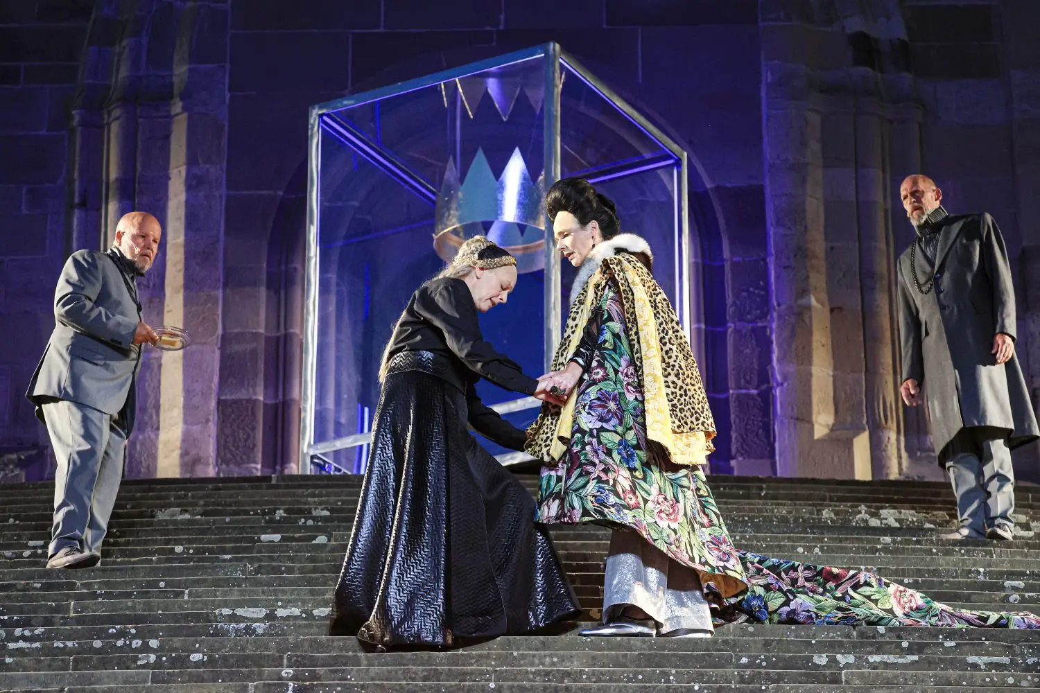 Schließlich treffen Maria Stuart (Martina Maria Reichert, in Schwarz) und Elisabeth (Franziska Becker) doch noch persönlich aufeinander. Symbolträchtig schwebt die riesige Krone über Marias Haupt. Die Königinnen werden flankiert vom Kerkermeister Paulet (Mario Gremlich, links) und dem Berater Shrewsbury (Claudius Freyer).⇥