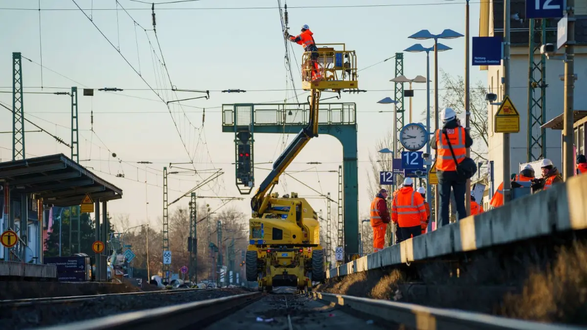 Eine Fachkraft führt auf einem hessischen Abschnitt der Riedbahn Arbeiten am Fahrdraht aus. Die komplette Strecke ist bis zum Morgen des 22. Januar gesperrt.