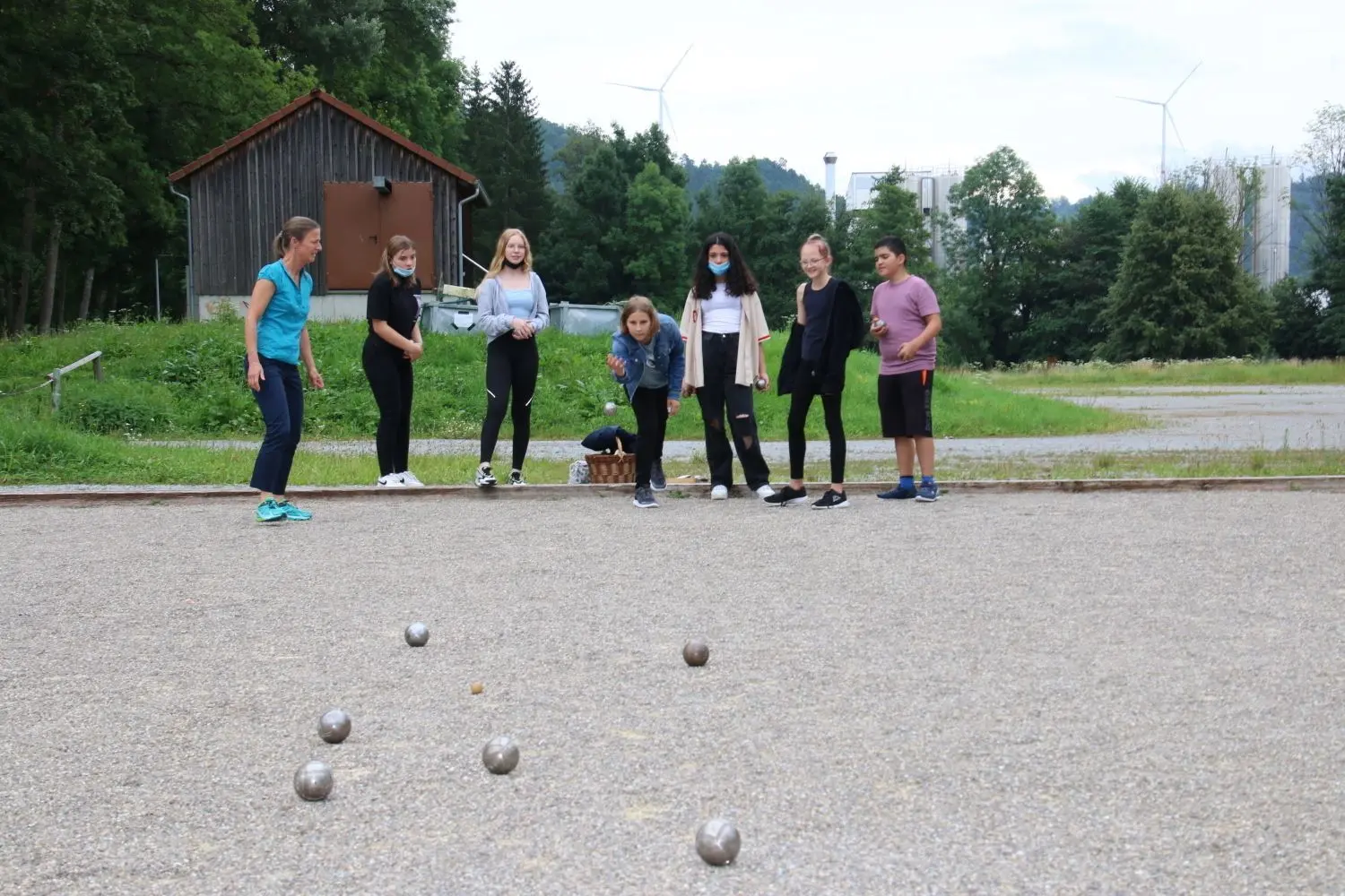 Die Französischklasse 7 der Schloss-Realschule spielt am letzten Schultag mit ihrer Lehrerin Petra Vinnai-Reith (links außen) eine Runde Boule auf der Gaildorfer Kocherwiese.⇥