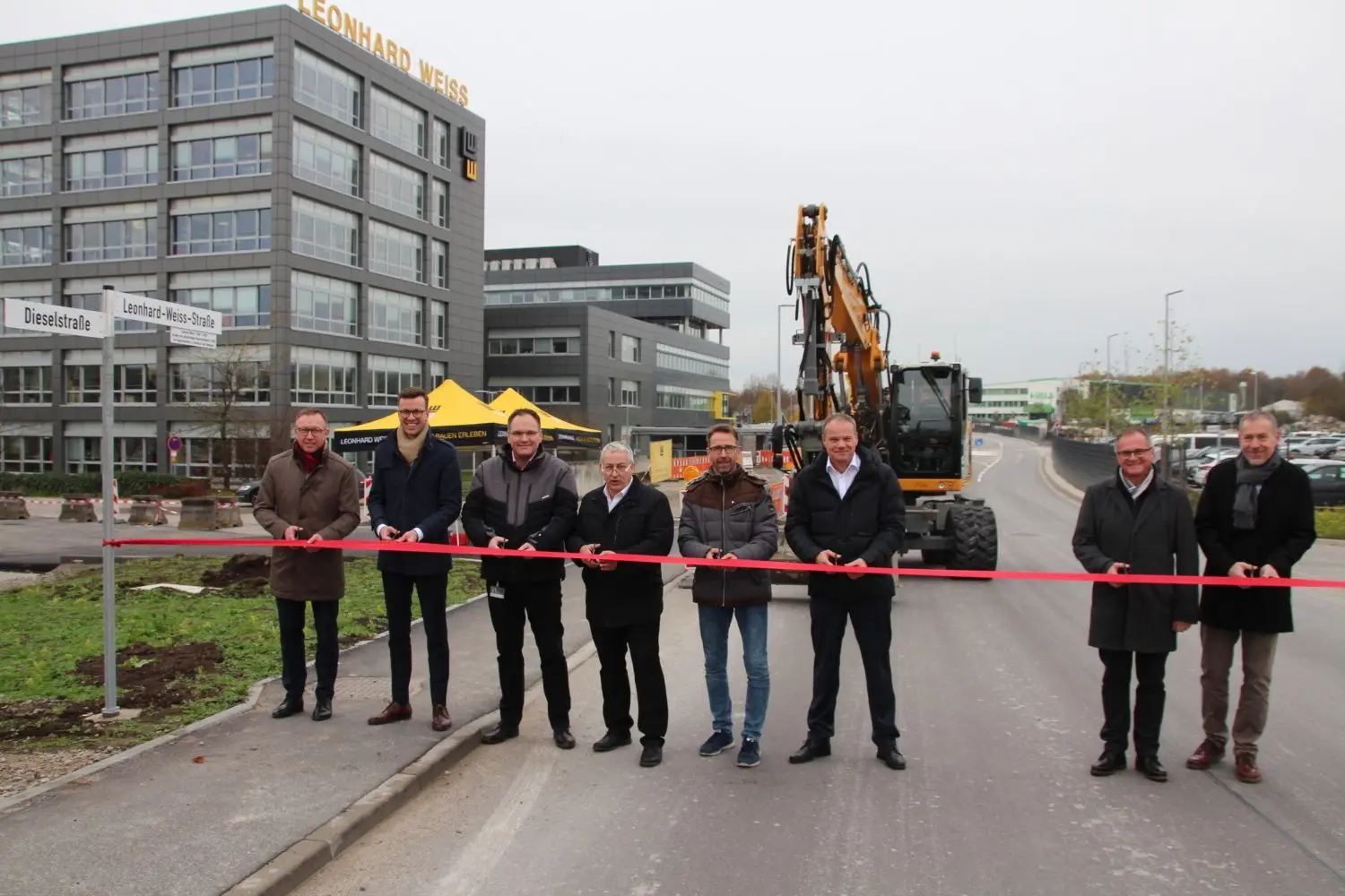 Die neue Leonhard-Weiss-Straße ist nun offiziell freigegeben: Marcus Herwarth, Thomas Haas, Ulf Honndorf, Ralf Schmidt, Jürgen Diem, Christian Ott, Reinhold Niebel und Jochen Hohneker (von links) beim Durchschneiden des Bands. ⇥