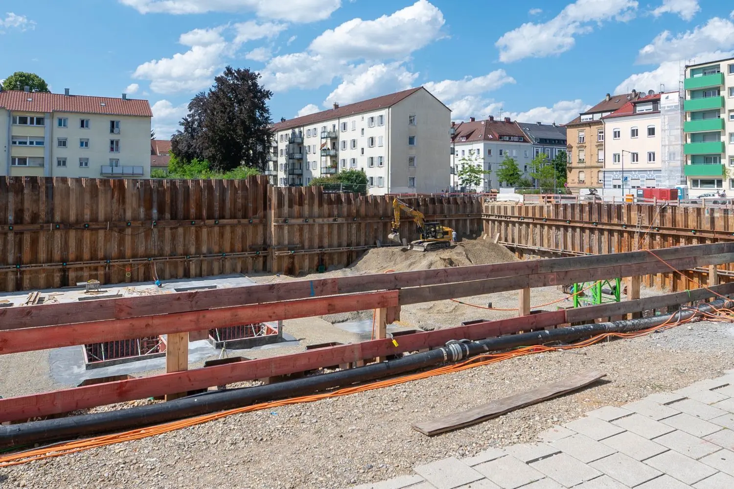 Gerade erst war der Aushub in der Baugrube des Heiners beendet worden, nun wird an Grenze zum Nachbarhaus wieder Erdreich angeschüttet. So soll das Gebäude stabilisiert werden.