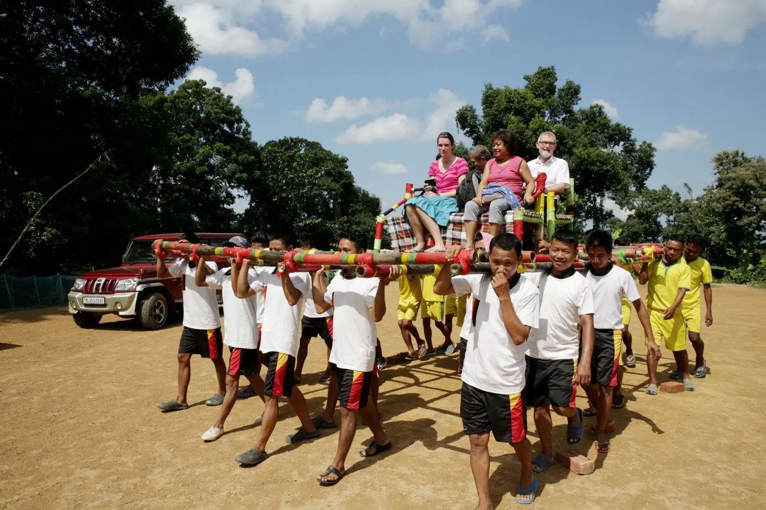 Gastfreundlicher Empfang: Auf einer überdimensionalen Sänfte werden die Besucher aus Deutschland (rechts Dekan Norbert Braun) zu dem offiziellen Festakt für das 100-jährige Bestehen der christlichen Gemeinde der Darlong getragen.