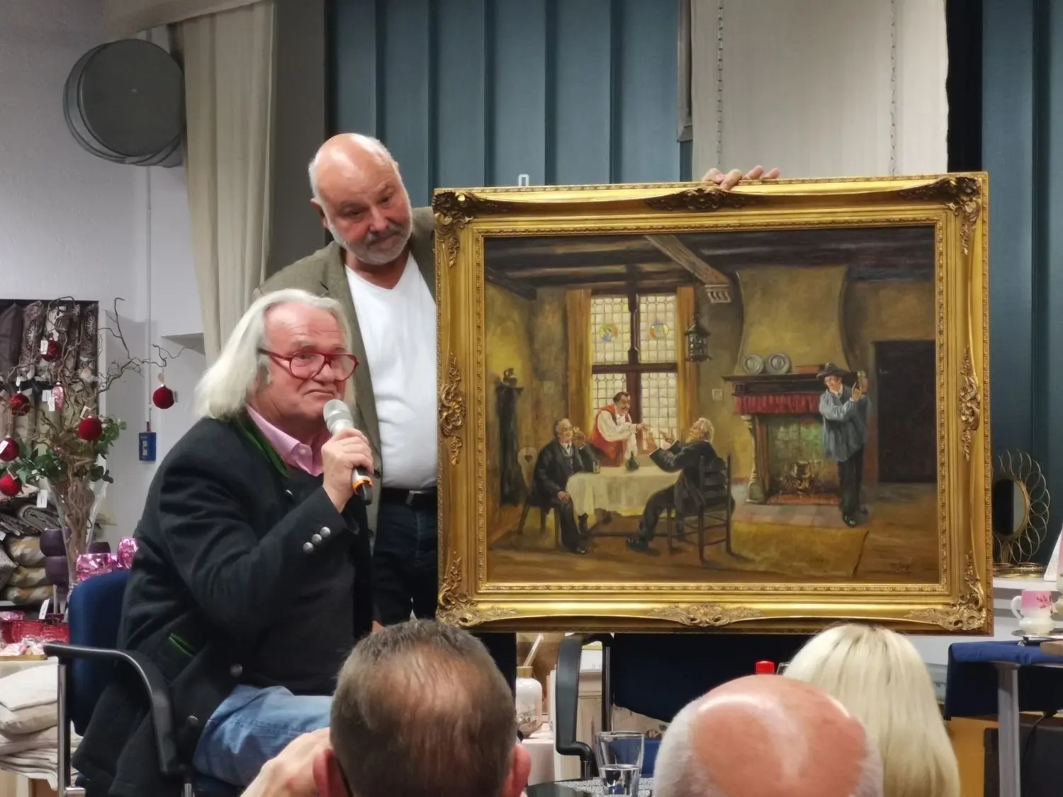 Der Kunsthändler Albert Maier aus Ellwangen (links) beurteilte bei seinem Besuch in Schrozberg auch mitgebrachte Kunstgegenstände wie ein großes Gemälde. Mit Bernhard Foos (rechts) stellte er auch das Buch vor, das sie gemeinsam erarbeitet haben.⇥
