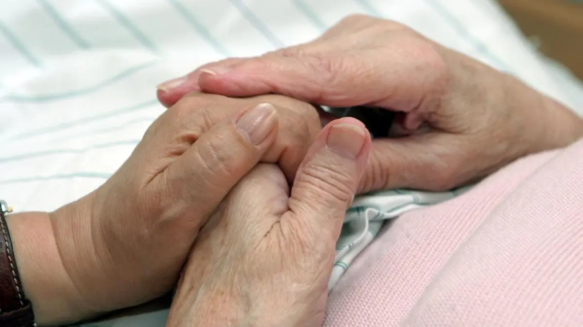 Eine Sterbebegleiterin hält die Hand einer Frau. Es hilft Angehörigen bei der Trauer und beim Abschiednehmen, wenn sie ihre Lieben in den letzten Stunden begleiten können.
Erika Nola (62), ehrenamtliche Sterbebegleiterin in den Altenpflegeheimen der "Bremer Heimstiftung", hält am 13.04.05 die Hand einer kranken Pflegeheimbewohnerin. "Viele Sterbende werden ruhig, wenn sich jemand an ihr Bett setzt und sie nicht alleine sind", sagt die 62-Jährige. Für ihre vorbildliche Sterbebegleitung in der stationären Altenpflege ist die "Bremer Heimstiftung" jetzt mit dem 5.000 Euro dotierten "Altenpflegepreis 2005" ausgezeichnet worden. Was das Projekt so bemerkenswert macht, ist die breite Basis, auf die es seine Initiatoren gestellt haben. Bewohner und Pflegekräfte, Angehörige und Ehrenamtliche, Ärzte und Altenpflege-Schüler arbeiten gemeinsam daran, dass in den 20 Wohn- und Pflegeeinrichtungen der Heimstiftung niemand allein gelassen wird. Ihr Ziel ist Beistand bis zuletzt. (Siehe epd-Feature vom 14.04.05)
Download am 20.0 8. 2018 für Mitschang/Langenau *** Local Caption *** 00136590