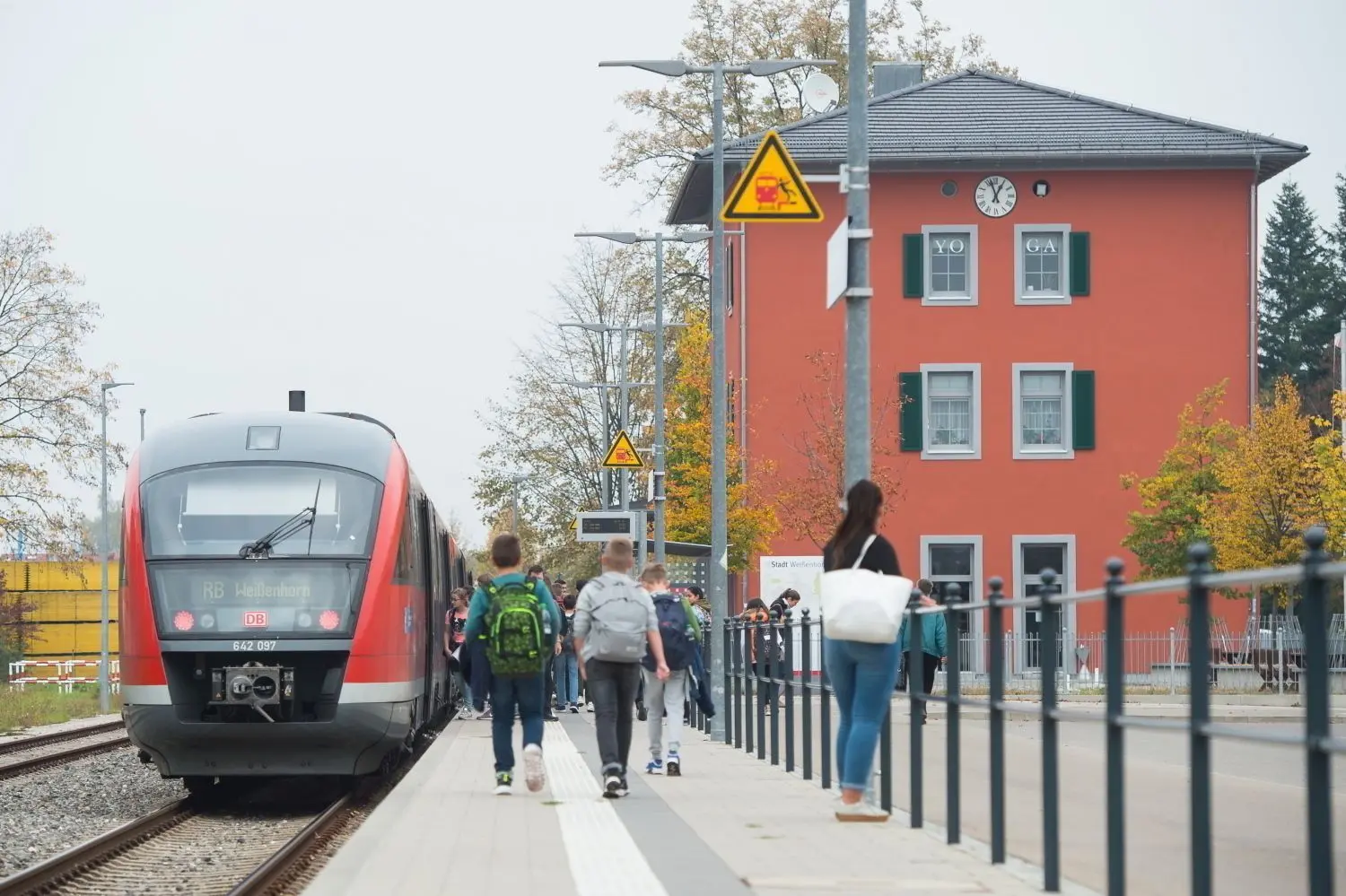 Politiker, Vertreter von Bahn, Ding und SWU sowie engagierte Bürger durchschneiden 2013 nach der Einfahrt des ersten planmäßigen Zuges nach 47 Jahren in Weißenhorn ein Band. Unten: Alltagsbetrieb mit modernen Fahrzeugen.