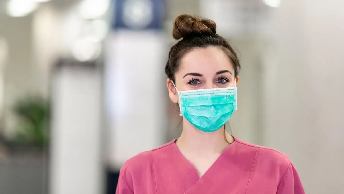 Der Mund-Nasen-Schutz (MNS oder OP-Masken) dient vor allem dem Schutz der Umgebung vor den Keimen, die der Träger durch Atmen oder Niesen verteilen könnte.
23.03.2020, Schleswig-Holstein, Kiel: Marie Noormalal schaut in die Kamera. Die 24-jährige Medizinstudentin gehört zu den ersten Freiwilligen in Kiel, die zur Unterstützung des Klinikpersonals im Städtischen Krankenhaus eingesetzt werden. Am Eingang des Krankenhauses macht sie eine Erstsichtung, um herausfinden, ob die Besucher potentiell infektiös sind. Wenn ja, werden Sie mit einem Mund-Nasen-Schutz ausgestattet und in den richtigen Behandlungspfad gelotst. (zu dpa: "Freiwillig im Krankenhaus: Helfen in der Corona-Krise") Foto: Frank Molter/dpa +++ dpa-Bildfunk +++