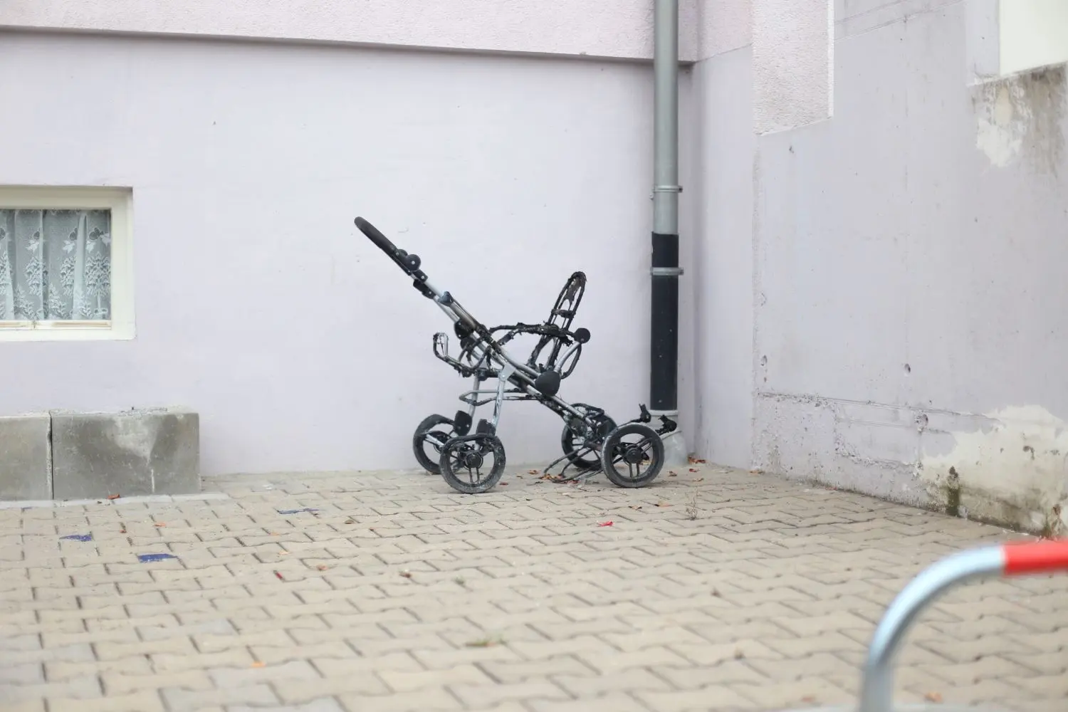 In der Konrad-Adenauer-Straße (oben) hat der brennende Kinderwagen die Fassade in Mitleidenschaft gezogen, in der Johann-Sattler-Straße (unten) stehen die Reste vor der Tür. ⇥