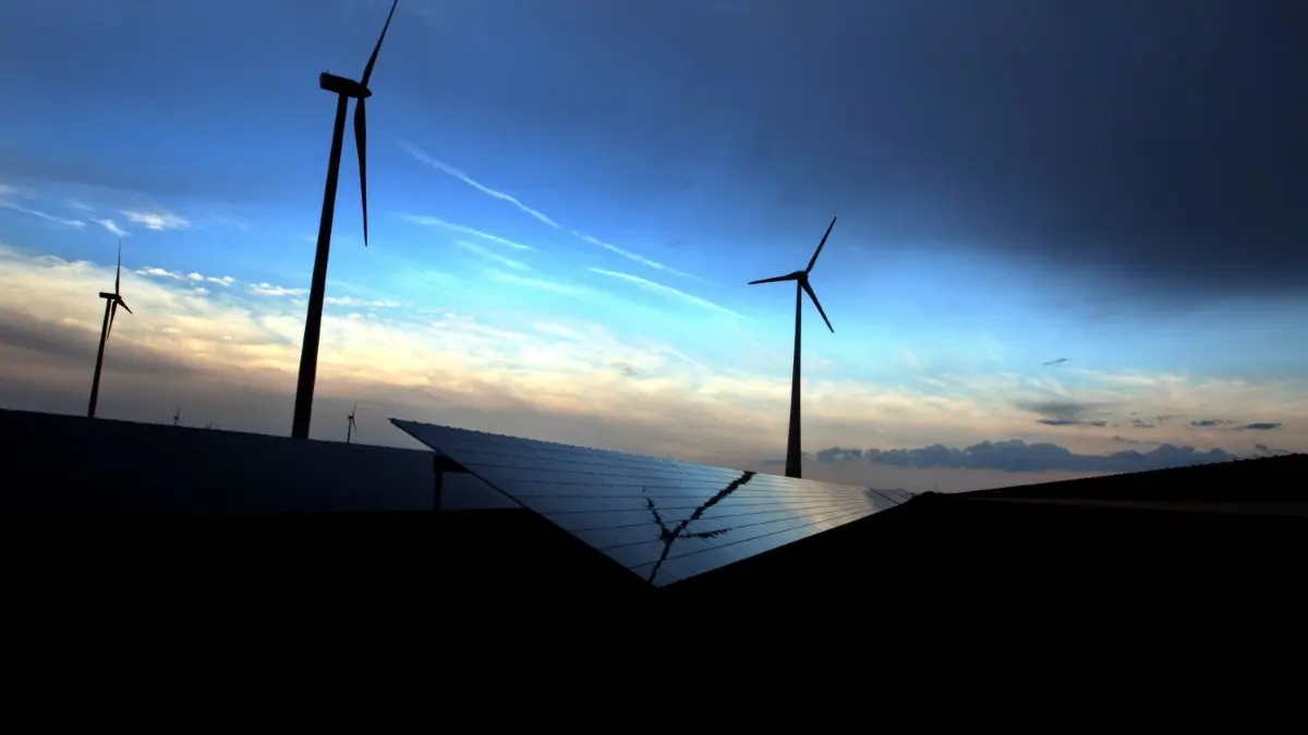 Dunkle Wolken über einer Solarkraftanlage und Windrädern: Laut BTU–Professor Harald Schwarz können Windkraft und Fotovoltaik nach dem Kohleausstieg keine gesicherte Stromversorgung in Deutschland gewährleisten.