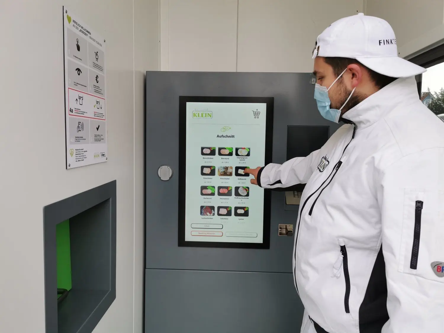 Josef Klein Jr. zeigt, wie Kunden am Automaten bestellen und bargeldlos bezahlen können.