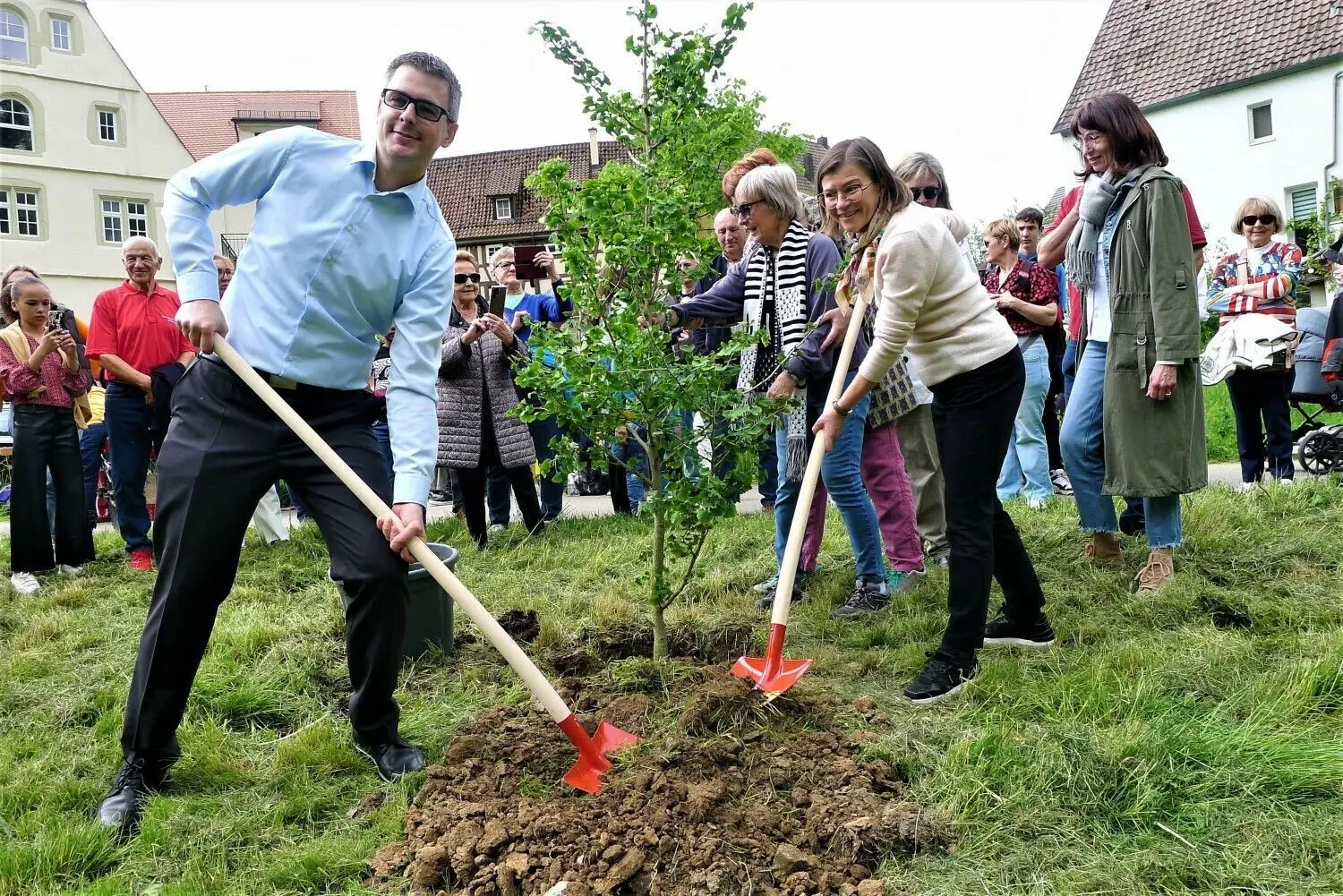 Das Geschenk für Haigerloch aus Noyal zum Partnerschaftsjubiläum war ein Ginkobaum, der am Samstag in den Eyachauen gepflanzt wurde. Das Bild zeigt Bürgermeister Heiko Lebherz und die Bürgermeisterin von Noyal, Marielle Muret-Baudoin, beim Schaufeln, während Angelika Pieper, die Haigerlocher Fördervereinsvorsitzende den Baum in der Senkrechten hält.