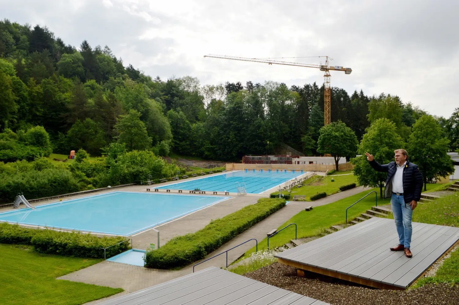 Schwimmmeister Markus Spingler bringt das Spendenbarometer für die Freibadsanierung auf den neusten Stand – 72 000 Euro.  Ulla Krämer, Leiterin der Stadtbücherei, bestückt das Bücherboot und Bürgermeister Mike Münzing freut sich auf den Terrrassenliegen des Münsinger Freibads auf den Saisonbeginn morgen. ⇥