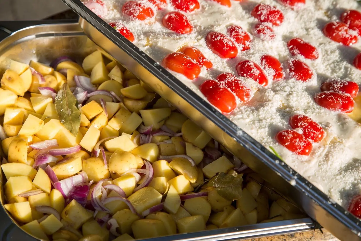Die Spinat-Tomaten-Lasagne oder das Kartoffel-Zwiebel-Gemüse werden in der Edelstahlküche im Kiosk an der Augsburger Straße vorbereitet.