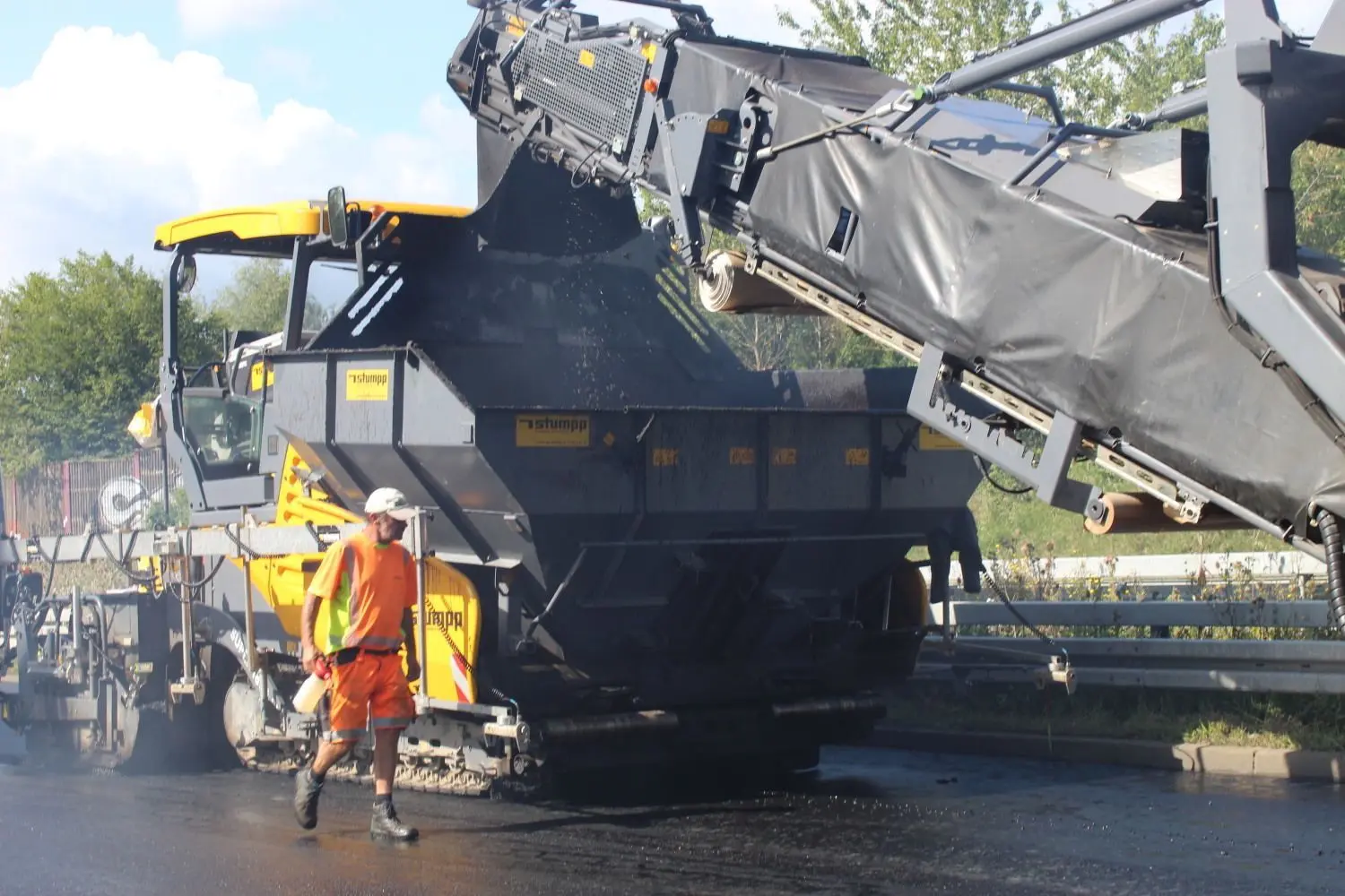 Das sogenannte Beschicker-Fahrzeug versorgt die Strecke ununterbrochen mit Asphaltmischgut.