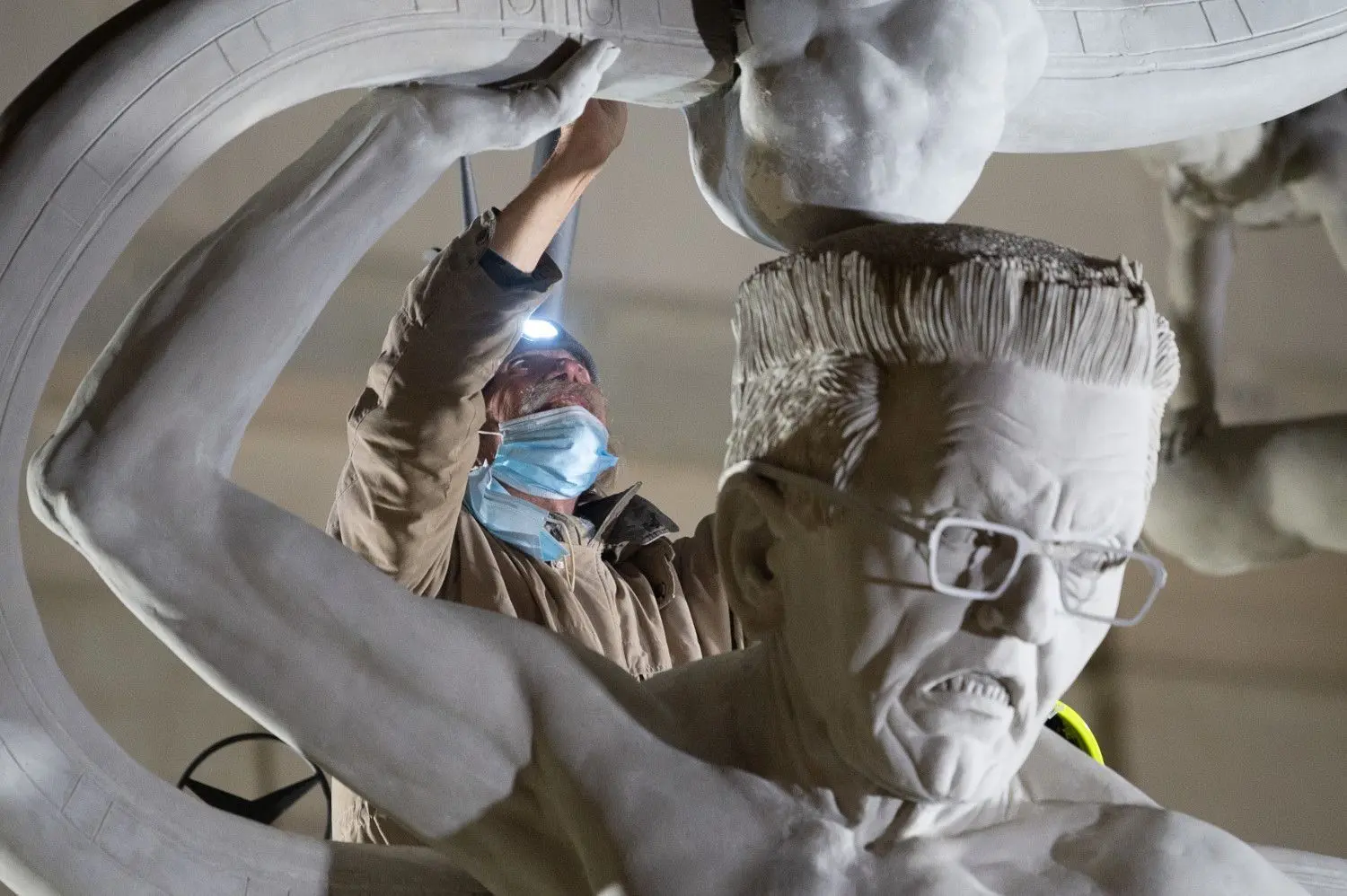 Nächtlicher Aufbau: Bildhauer Peter Lenk auf Tuchfühlung mit dem Herzstück seiner S21-Skulptur. Ministerpräsident Winfried Kretschmann fühlt sich als „Laokoon“ im Kampf mit dem Projekt gut getroffen. ⇥