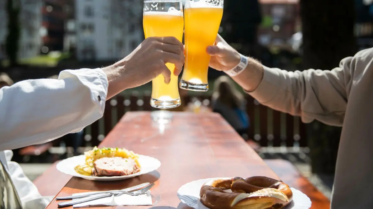 Ob Leberkäse mit Brezel und Hefeweizen oder vegetarische Alternativen wie Käseknödel: Die Auswahl an Speisen und Getränken ist in vielen Biergärten groß.
ARCHIV - 28.03.2021, Baden-Württemberg, Tübingen: Zwei Menschen sitzen bei gutem Wetter in einem Biergarten und stoßen mit einem Bier an. Nach monatelangem Corona-Lockdown können sich die Menschen in einigen Regionen im Südwesten vom 15.05.2021 an wieder auf Besuche im Restaurant, im Hotel, im Freibad oder im Museum freuen. Foto: Tom Weller/dpa +++ dpa-Bildfunk +++