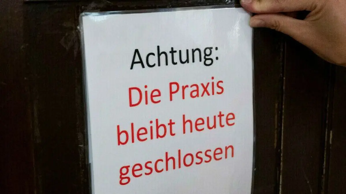 Eingeschränkte Versorgung: In Brandenburg reduzieren viele Hausärzte aus Protest in der ersten Oktoberwoche die Zahl ihrer Sprechstunden. Wie ist die Situation in Eisenhüttenstadt? (Symbolbild)
07.09.2022, Berlin: Kerstin Zeise, Ärztin, hängt ein Hinweisschild mit der Aufschrift ·Achtung: Die Praxis bleibt heute geschlossen - Aktionstag 7. September· an die Eingangstür ihrer Arztpraxis. Die Kassenärztliche Vereinigung (KV) ruft zu einem Aktionstag auf, viele Berliner Arztpraxen wollen schließen. Sie protestieren damit gegen die im Bundeskabinett beschlossene Streichung der Neupatientenregelung. Foto: Christophe Gateau/dpa +++ dpa-Bildfunk +++