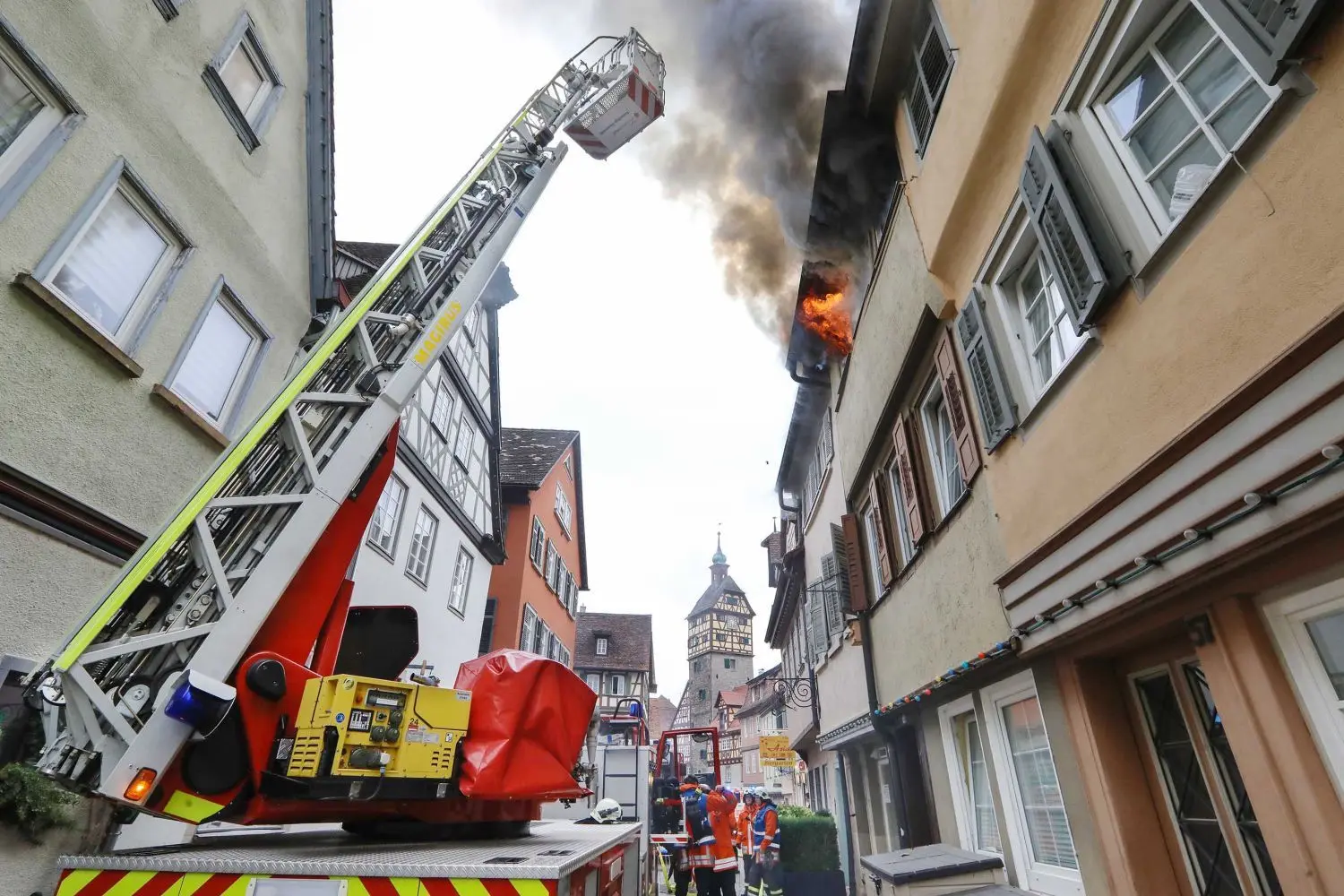 Flammen schlagen aus den Fenstern im zweiten Stock. Zwei Feuerwehrmänner verschaffen sich derweil von der Drehleiter aus einen Überblick und prüfen, ob Feuer oder Rauch noch aus anderen Ecken herausdringt.⇥